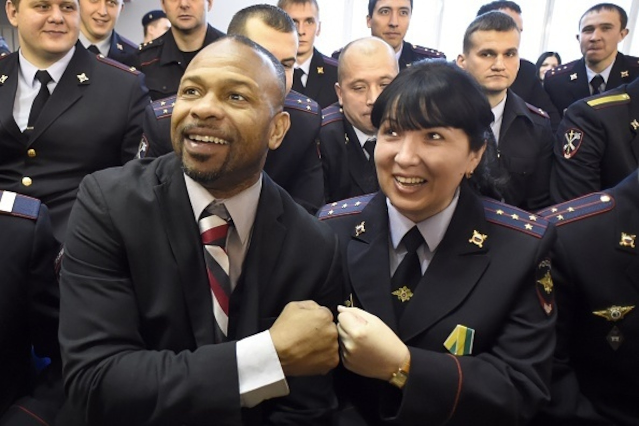 Boxer Roy Jones Jr. (L), who recently became a Russian citizen, poses for pictures with Russia's police officers during his masterclass in Moscow on December 8, 2015. AFP PHOTO / ALEXANDER NEMENOV / AFP / ALEXANDER NEMENOV        (Photo credit should read