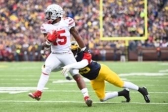 Nov 28, 2015; Ann Arbor, MI, USA; Ohio State Buckeyes running back Ezekiel Elliott (15) is tackled by Michigan Wolverines safety Dymonte Thomas (25) at Michigan Stadium. Mandatory Credit: Tim Fuller-USA TODAY Sports