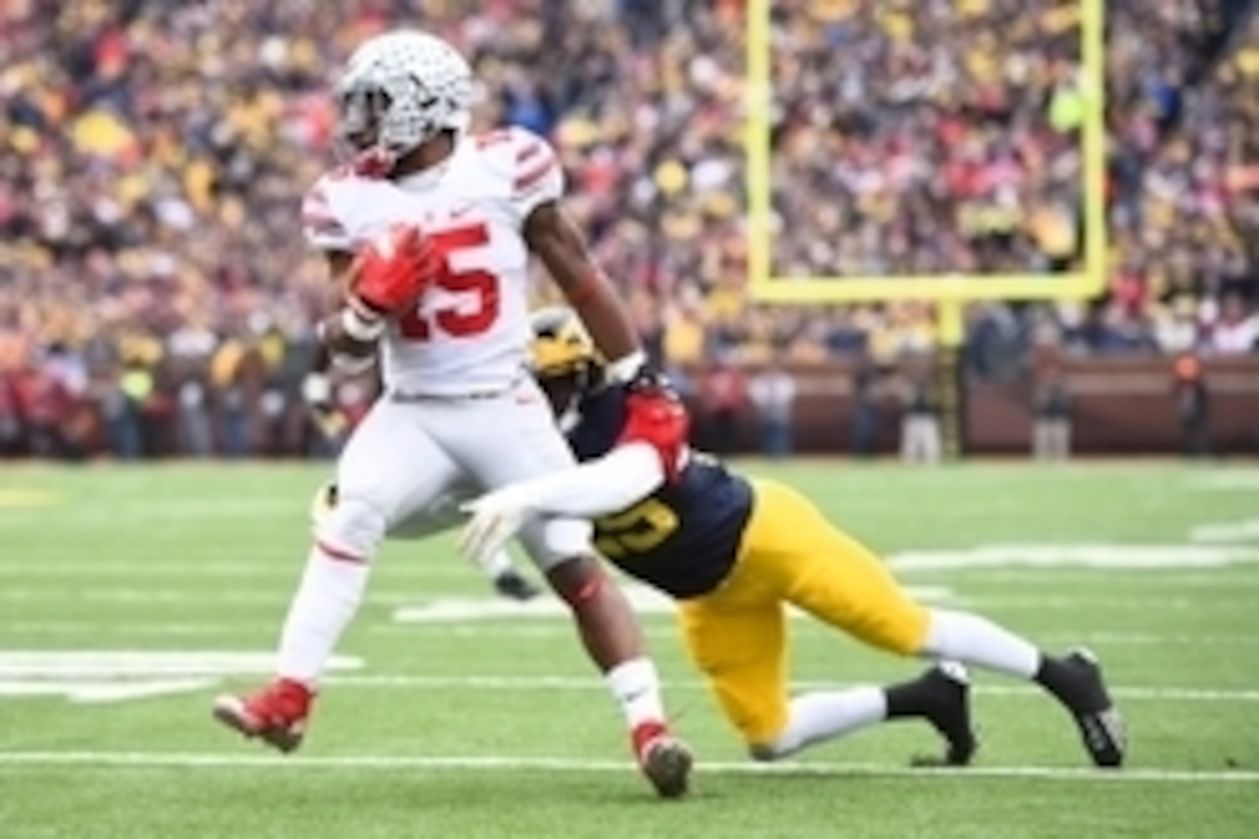 Nov 28, 2015; Ann Arbor, MI, USA; Ohio State Buckeyes running back Ezekiel Elliott (15) is tackled by Michigan Wolverines safety Dymonte Thomas (25) at Michigan Stadium. Mandatory Credit: Tim Fuller-USA TODAY Sports