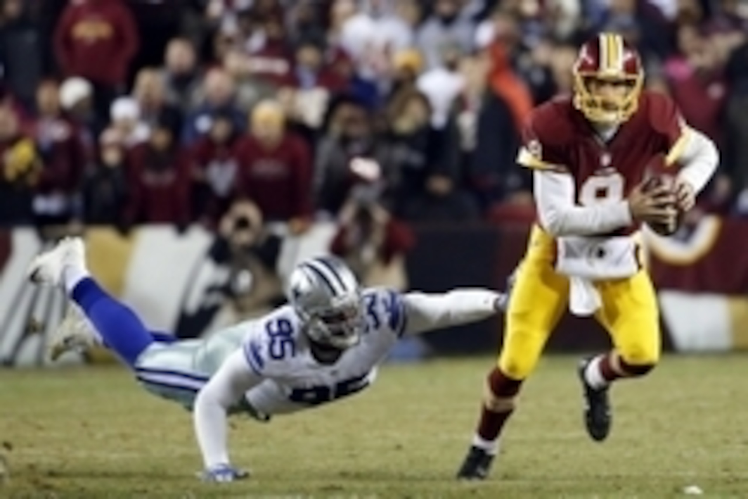 Dec 7, 2015; Landover, MD, USA; Washington Redskins quarterback Kirk Cousins (8) runs with the ball as Dallas Cowboys defensive tackle David Irving (95) attempts the tackle in the fourth quarter at FedEx Field. The Cowboys won 19-16. Mandatory Credit: Geo