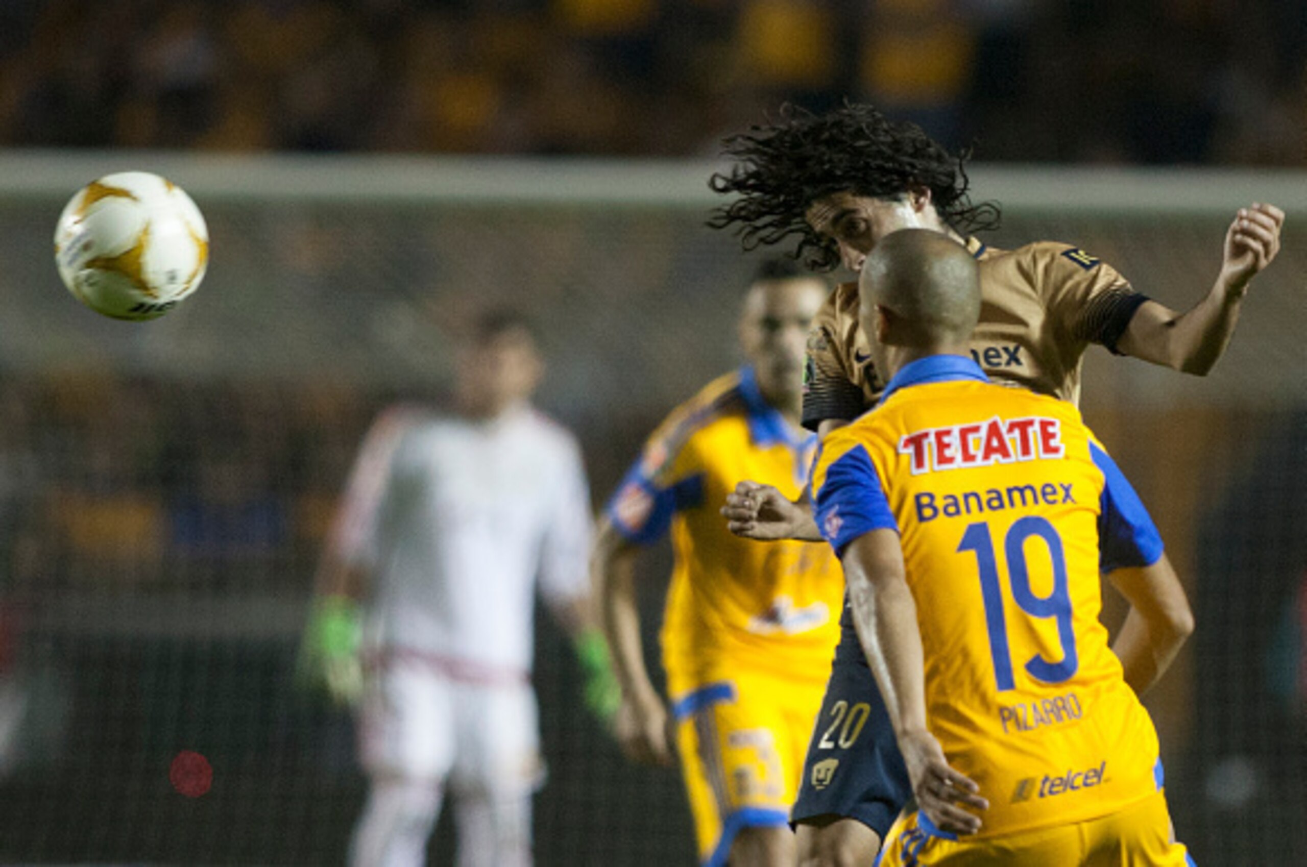 Guido Pizarro (R) of Tigres vies for the ball with Matias Britos (L) of Pumas during the first leg of the final of the Mexican Apertura 2015 tournament football match at the Universitario stadium in Monterrey, Mexico. On December 10, 2015. AFP PHOTO/Julio