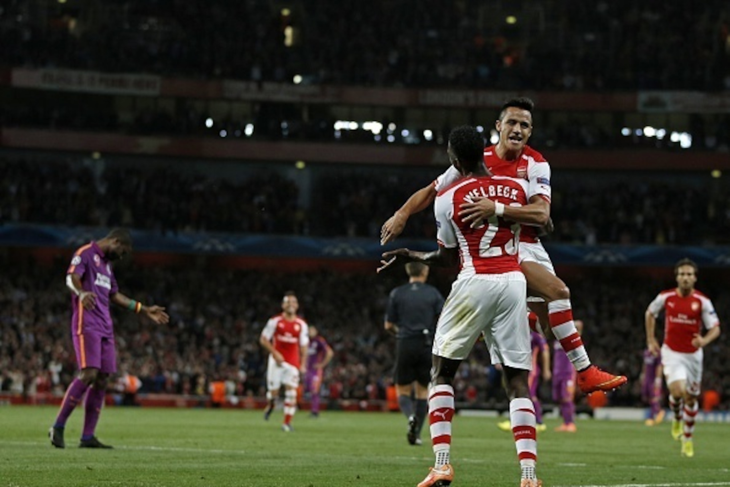 Arsenal's Chilean striker Alexis Sanchez (up) celebrates with Arsenal's English striker Danny Welbeck during the UEFA Champions League, Group D football match between Arsenal and Galatasaray at The Emirates Stadium in north London on October 1, 2014. AFP 
