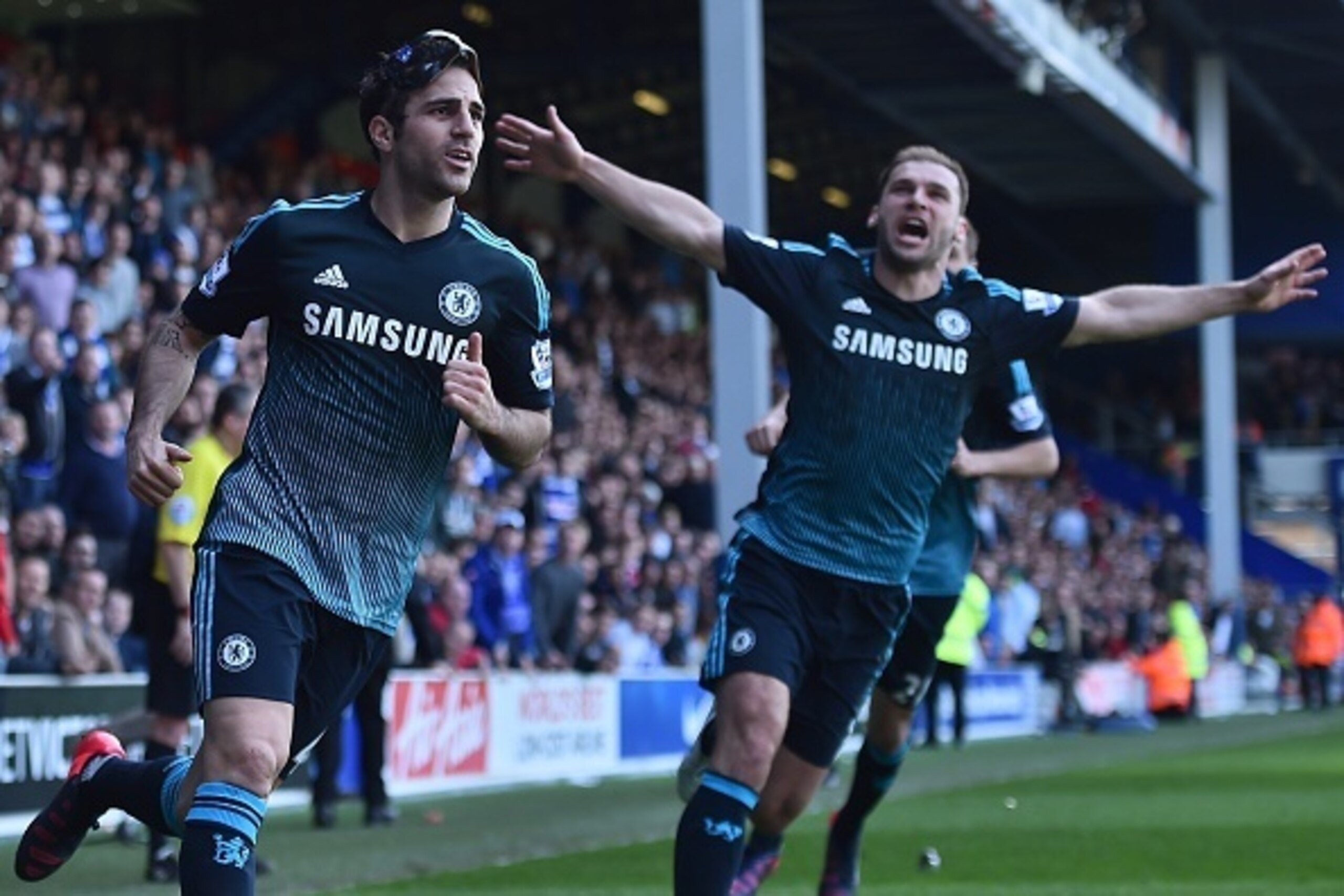 Chelsea's Spanish midfielder Cesc Fabregas (L) celebrates with Chelsea's Serbian defender Branislav Ivanovic (R) after scoring their goal during the English Premier League football match between Queens Park Rangers and Chelsea at Loftus Road Stadium in Lo