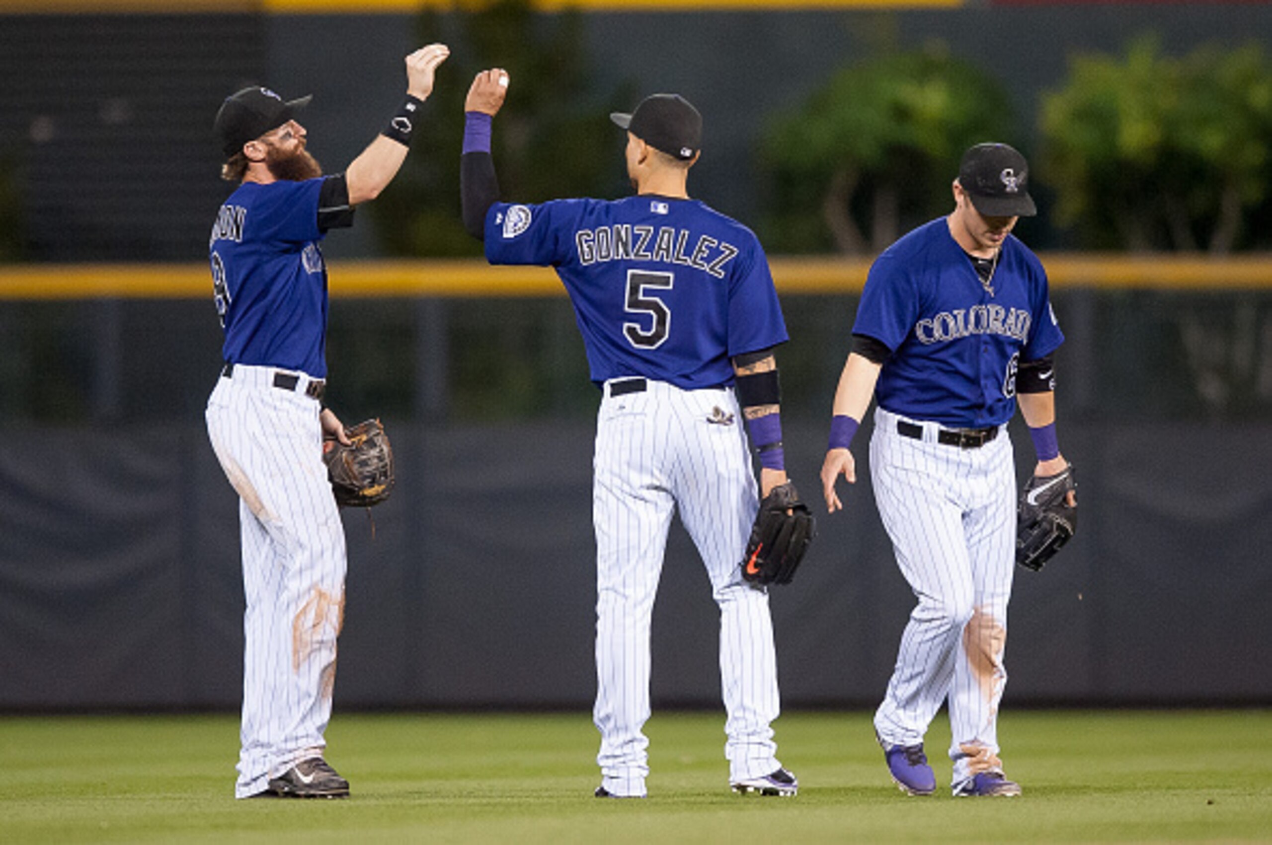 DENVER, CO - SEPTEMBER 25:  Charlie Blackmon #19, Carlos Gonzalez #5, and Corey Dickerson #6 of the Colorado Rockies celebrate a 7-4 win over the Los Angeles Dodgers after a game   at Coors Field on September 25, 2015 in Denver, Colorado.  (Photo by Dusti