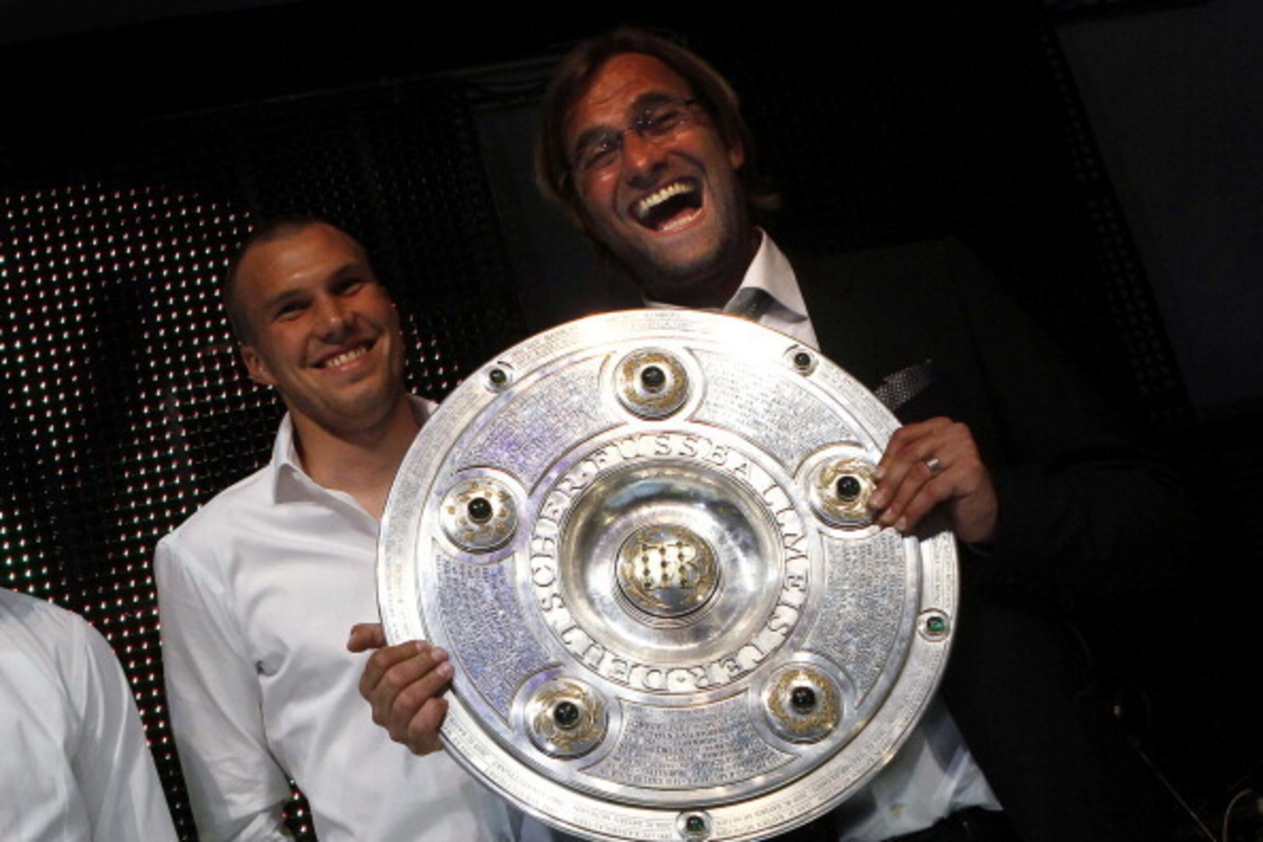Juergen Klopp (R), coach of German soccer champion Borussia Dortmund, presents the German soccer championship trophy together with his midfielder Kevin Grosskreutz prior to a dinner after the German first division Bundesliga football match Borussia Dortmu