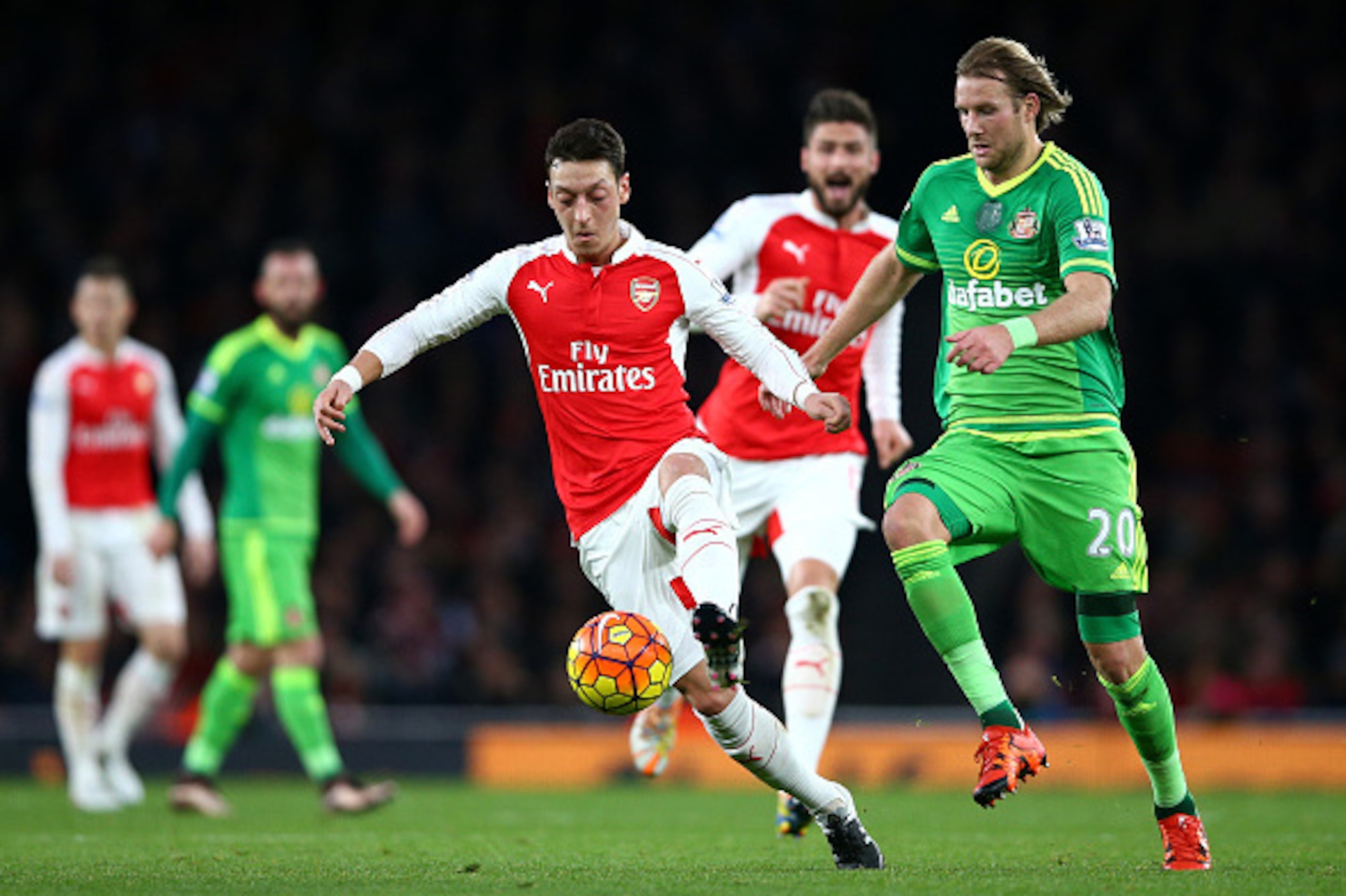 LONDON, ENGLAND - DECEMBER 05: Mesut Ozil of Arsenal and Ola Toivonen of Sunderland compete for the ball during the Barclays Premier League match between Arsenal and Sunderland at Emirates Stadiumon December 5, 2015 in London, England.  (Photo by Paul Gil