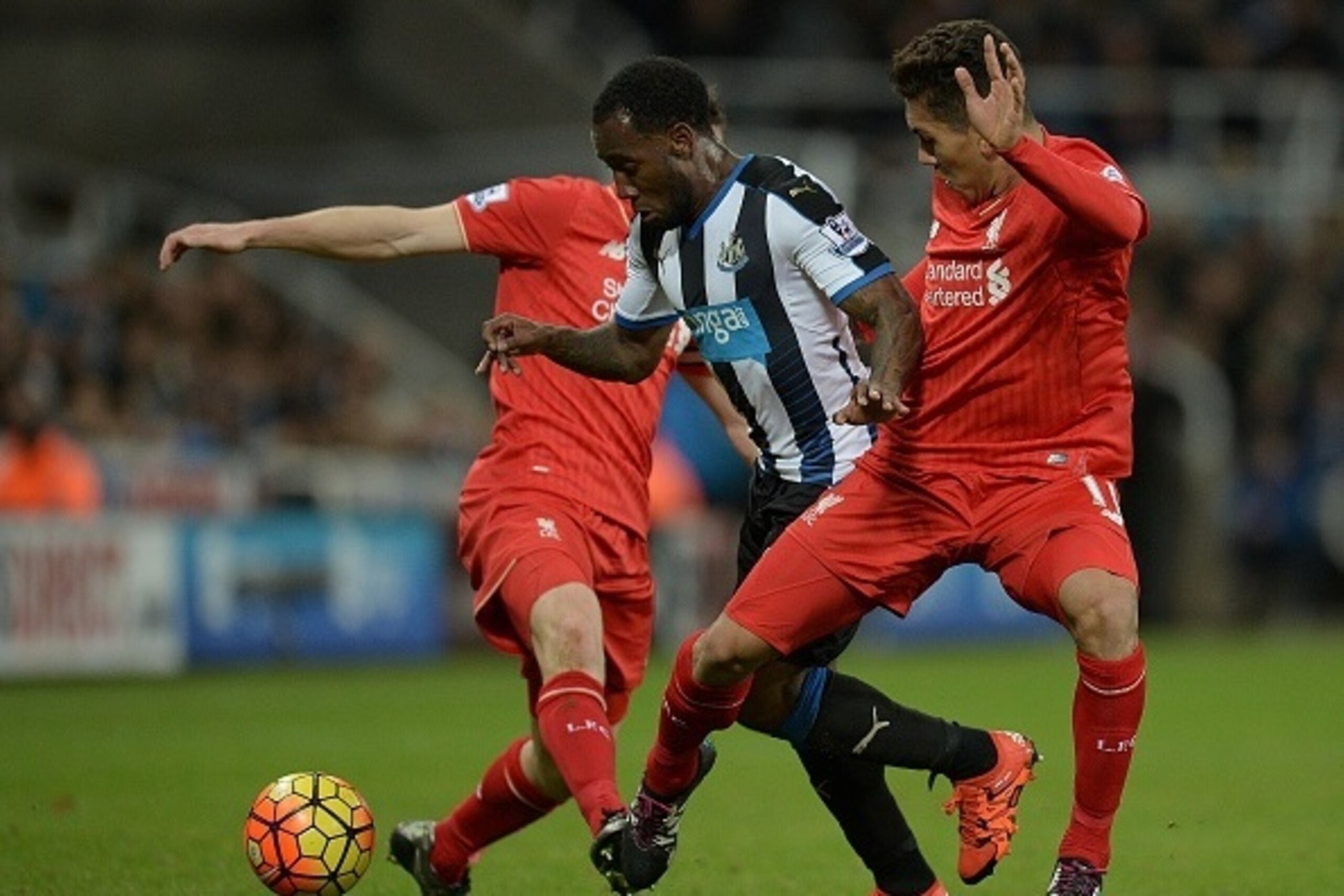 Newcastle United's Dutch midfielder Vurnon Anita (C) vioes with Liverpool's English midfielder James Milner and Liverpool's Brazilian midfielder Roberto Firmino during the English Premier League football match between Newcastle United and Liverpool at St Newcastle United's Dutch midfielder Vurnon Anita (C) vioes with Liverpool's English midfielder James Milner and Liverpool's Brazilian midfielder Roberto Firmino during the English Premier League football match between Newcastle United and Liverpool at St