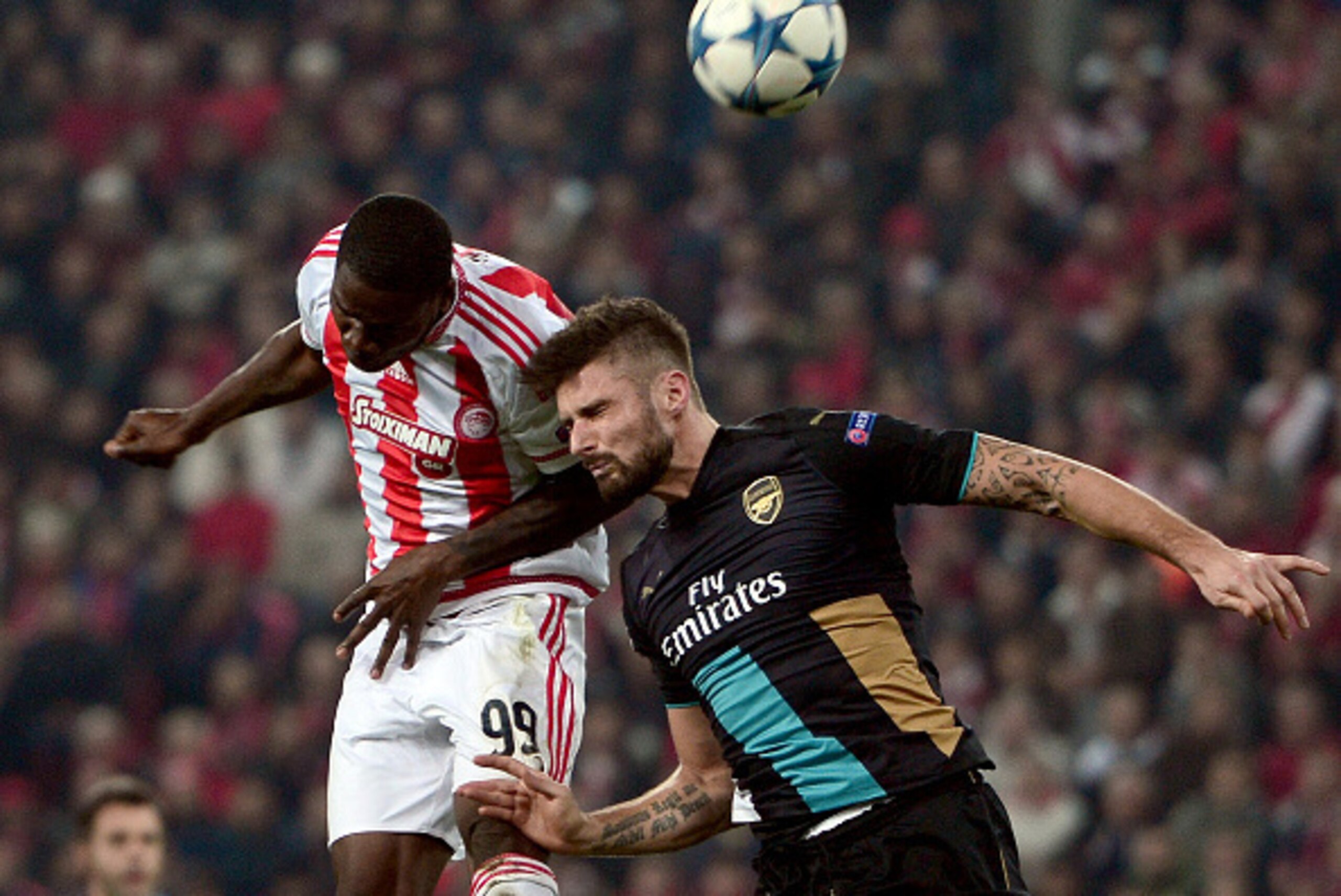 Arsenal's French forward Olivier Giroud (R) goes for a header with Olympiacos' Ideye Brown during the UEFA Champions League Group F football match between Olympiacos and Arsenal at the Georgios Karaiskakis Stadium in Piraeus near Athens on December 9, 201