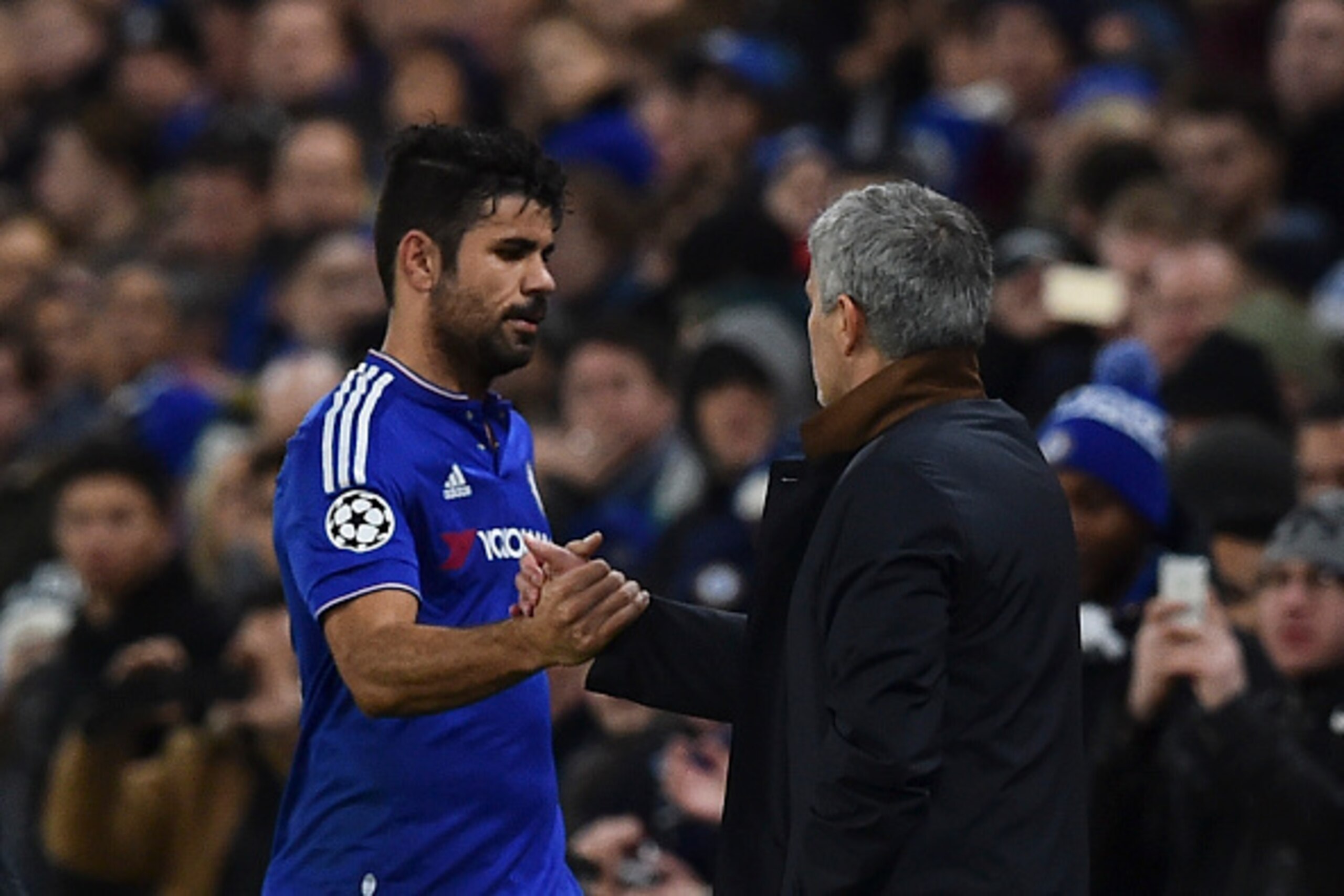 Chelsea's Portuguese manager Jose Mourinho (R) shakes hands with Chelsea's Brazilian-born Spanish striker Diego Costa (L) as Costa is substituted and leaves the pitch during the UEFA Champions League Group G football match between Chelsea and Porto at Sta