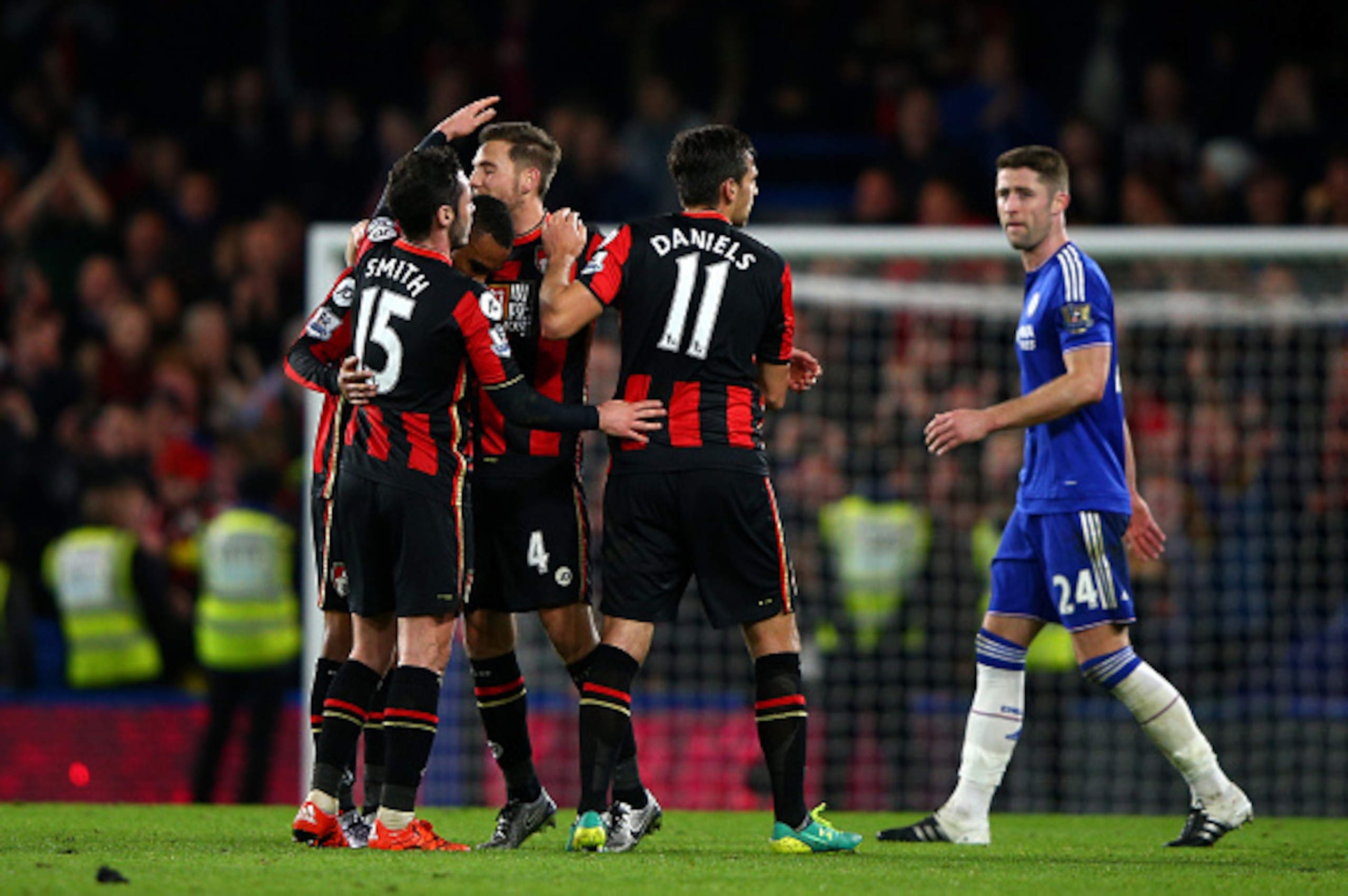LONDON, ENGLAND - DECEMBER 05:  Bournemouth players Adam Smith (1sr L), Junior Stanislas (2nd L), Dan Gosling (3rd L) and Charlie Daniels (2nd R) celebrate their 1-0 win while Gary Cahill (1st R) of Chelsea leaves the pitch after the Barclays Premier Leag