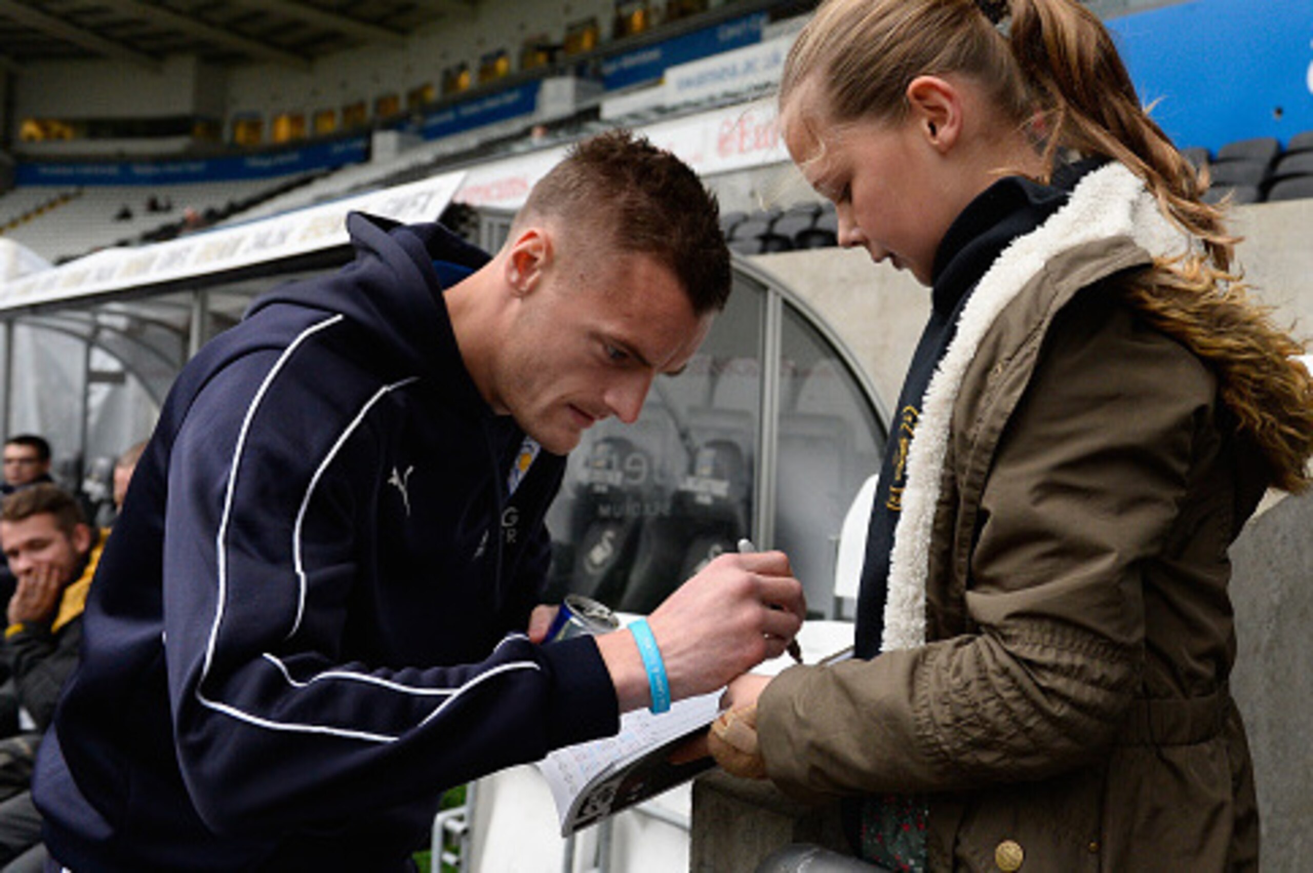 SWANSEA, WALES - DECEMBER 05:  Leicester striker Jamie Vardy signs a young fans autograph book before the Barclays Premier League match between Swansea City and Leicester City at Liberty Stadium on December 5, 2015 in Swansea, Wales.  (Photo by Stu Forste