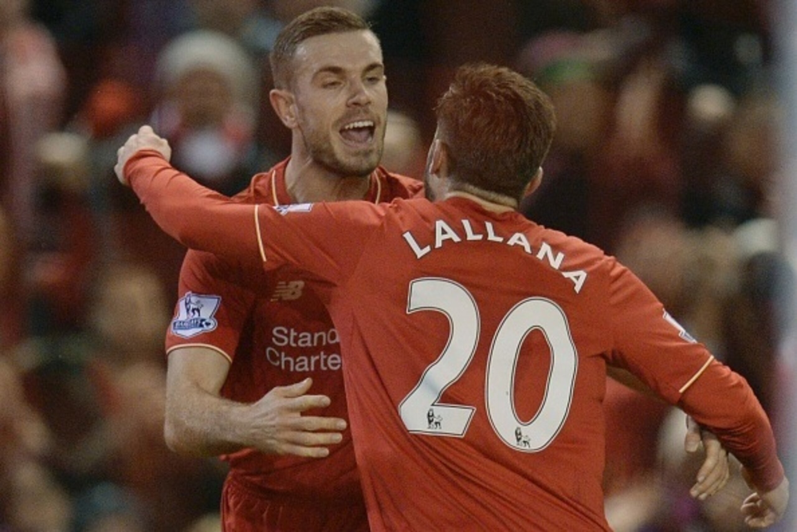 Liverpool's English midfielder Jordan Henderson (L) celebrates with Liverpool's English midfielder Adam Lallana (R) after scoring the opening goal during the English Premier League football match between Liverpool and West Bromwich Albion at Anfield in Li