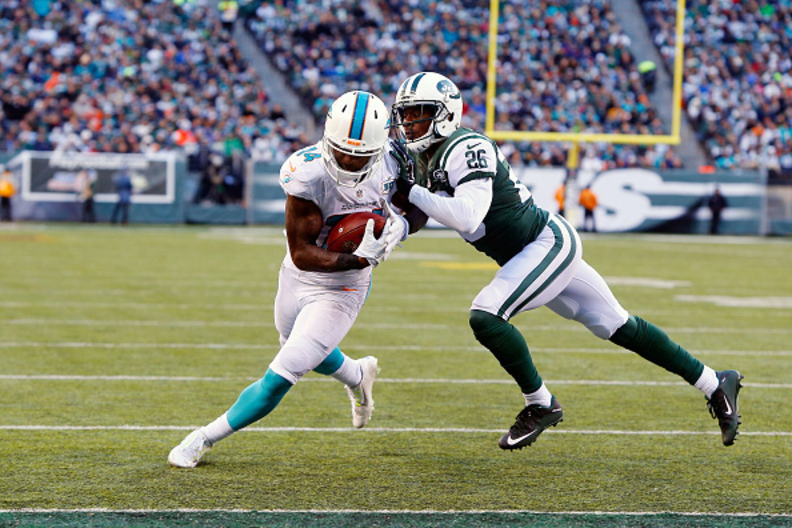 EAST RUTHERFORD, NJ - NOVEMBER 29: (NEW YORK DAILIES OUT) Jarvis Landry #14 of the Miami Dolphins runs in a touchdown against Darrin Walls #26 of the New York Jets on November 29, 2015 at MetLife Stadium in East Rutherford, New Jersey. The Jets defea EAST RUTHERFORD, NJ - NOVEMBER 29: (NEW YORK DAILIES OUT) Jarvis Landry #14 of the Miami Dolphins runs in a touchdown against Darrin Walls #26 of the New York Jets on November 29, 2015 at MetLife Stadium in East Rutherford, New Jersey. The Jets defea