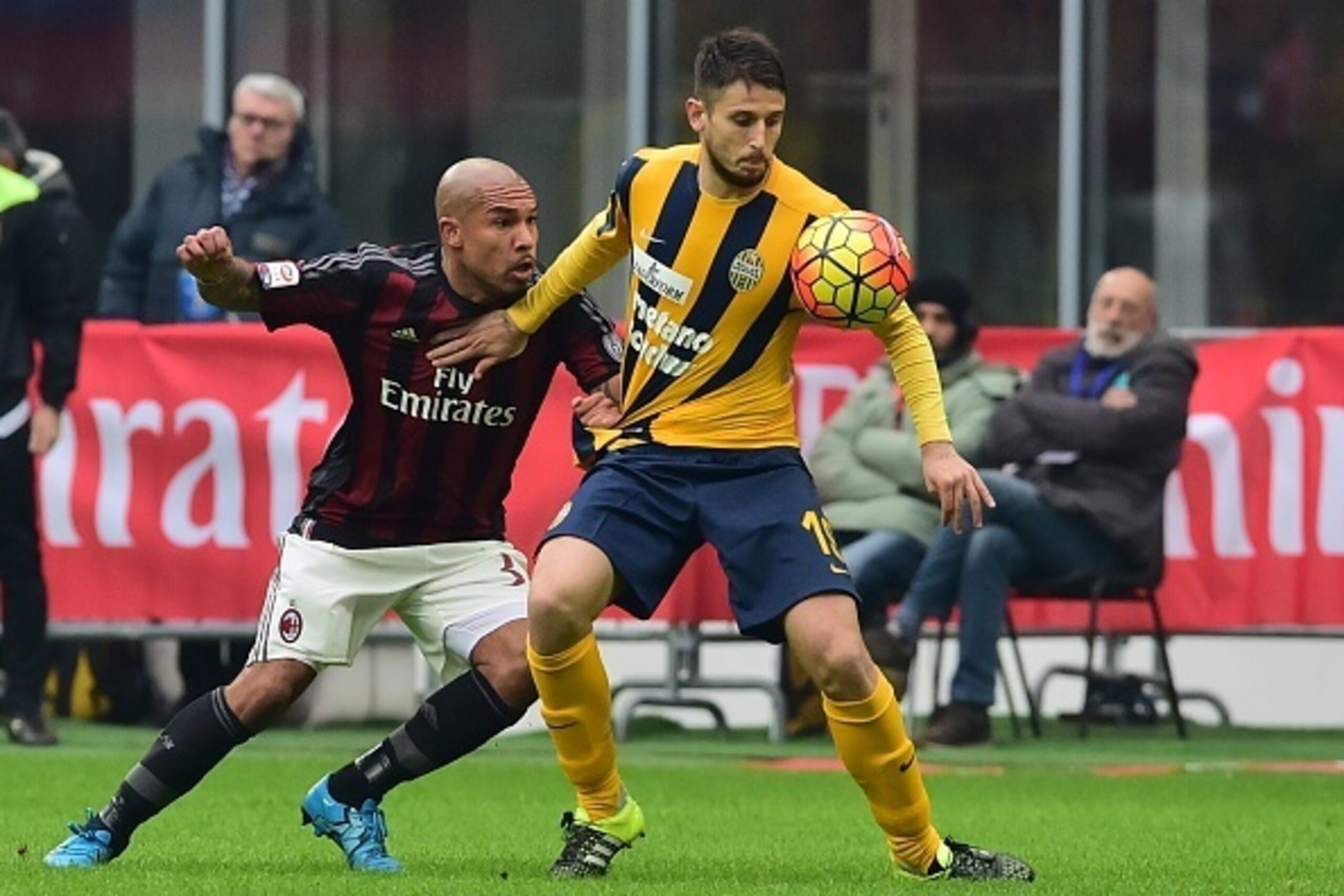Milan's Dutch midfielder Nigel de Jong (L) vies with Verona's Italian midfielder Leandro Greco during the Italian Serie A football match between AC Milan and Hellas Verona at the San Siro Stadium in Milan on December 13, 2015. / AFP / GIUSEPPE CACACE     