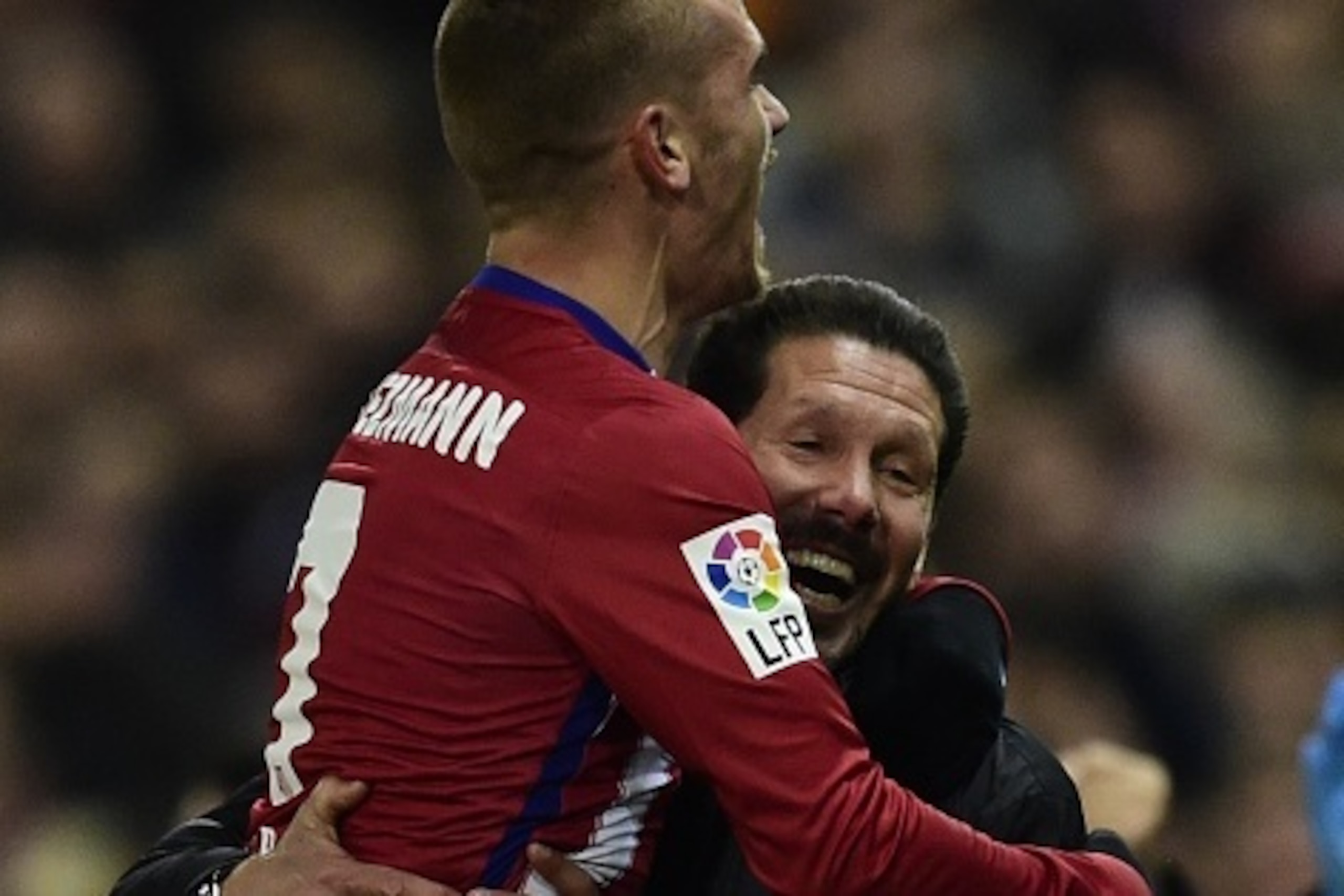 Atletico Madrid's French forward Antoine Griezmann (L) celebrates with Atletico Madrid's Argentinian coach Diego Simeone after scoring a goal during the Spanish league football match Club Atletico de Madrid vs Athletic Club Bilbao at the Vicente Calderon 
