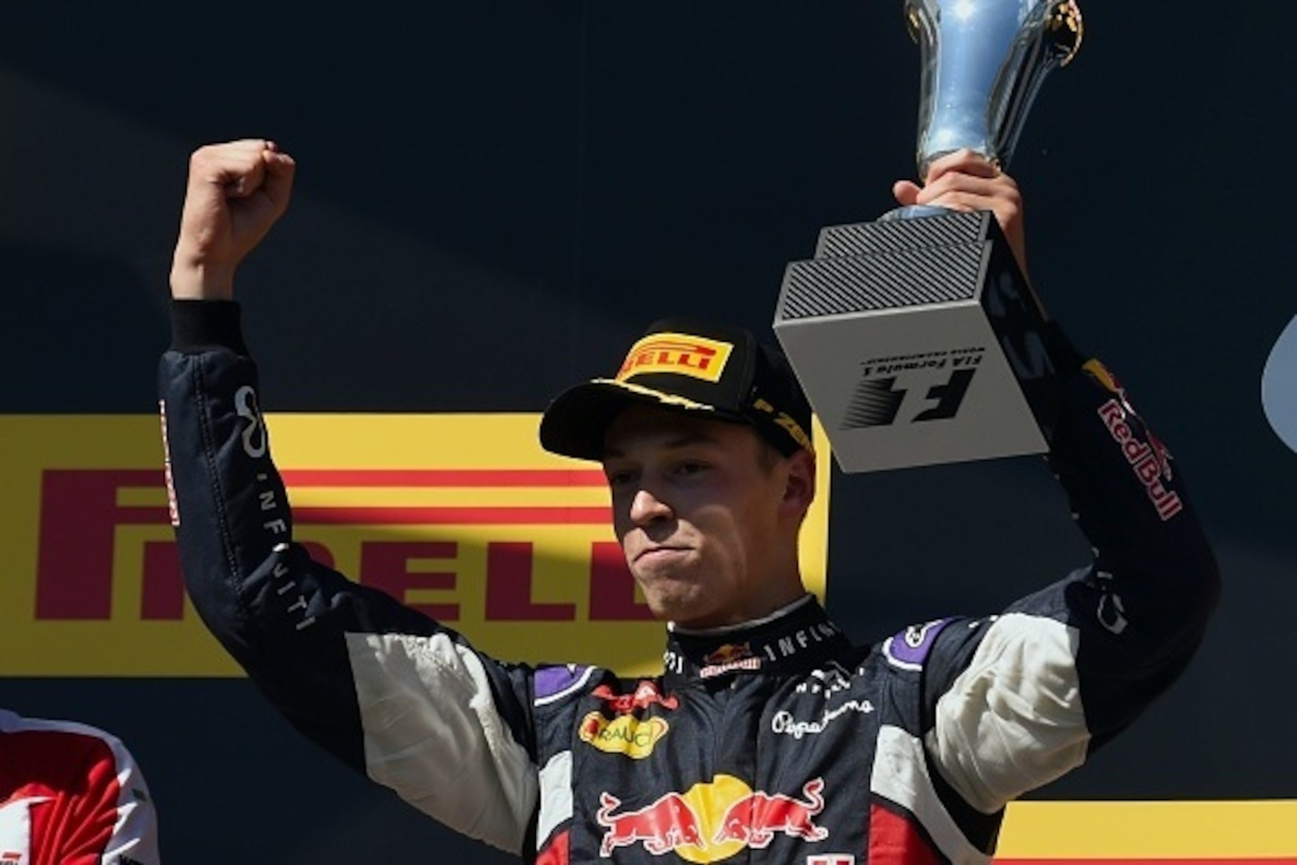 Infiniti Red Bull Racing's Russian driver Daniil Kvyat celebrates on the podium with his trophy after the Hungarian Formula One Grand Prix at the Hungaroring circuit near Budapest on July 26, 2015.  Ferrari's German driver Sebastian Vettel wins ahead of I