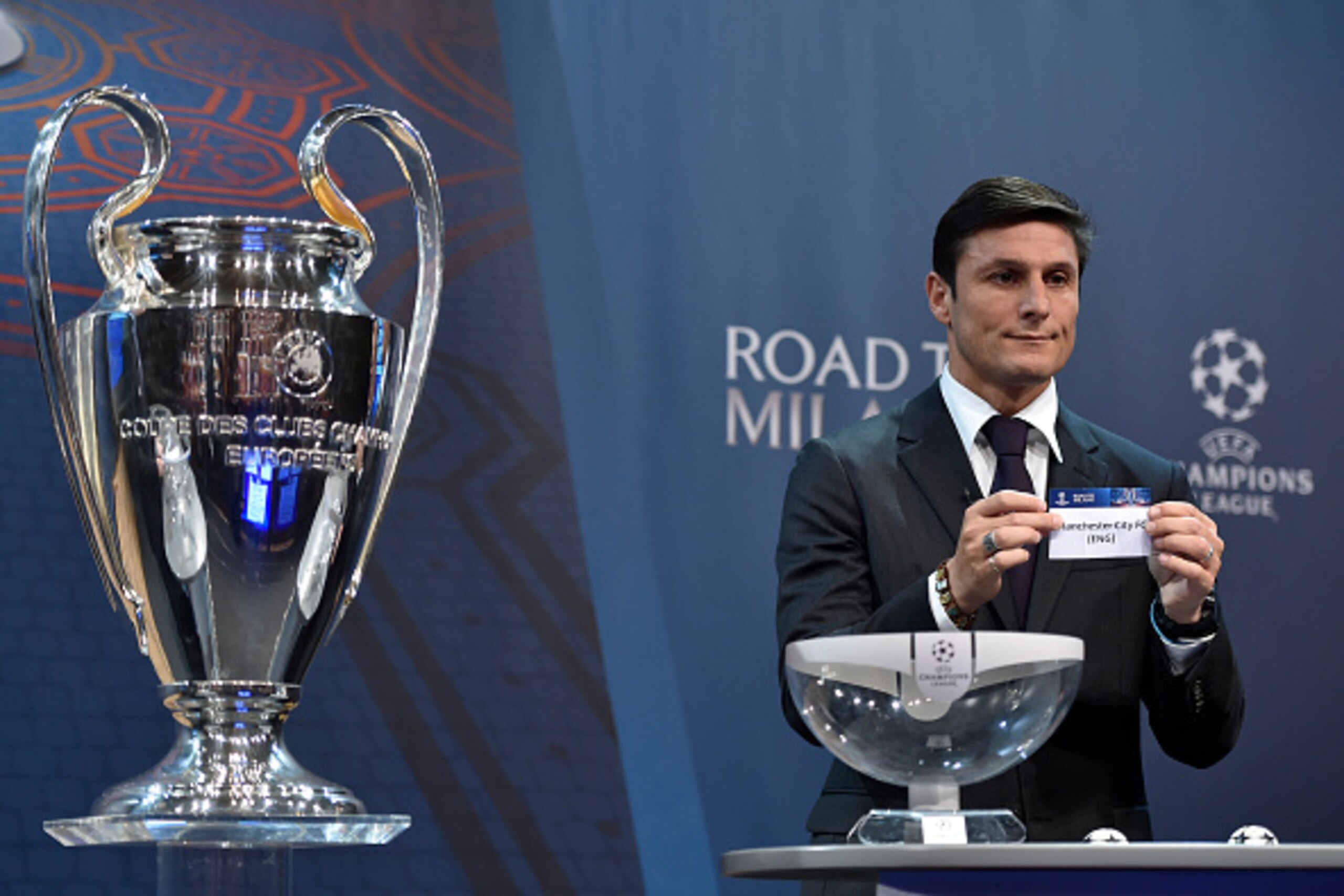 UEFA Champions League final ambassador  Javier Zanetti  shows the name of Manchester City football club during the draw for the UEFA Champions league round of sixteen, on December 14, 2015 at the UEFA headquarters in Nyon.  AFP PHOTO / FABRICE COFFRINI / 