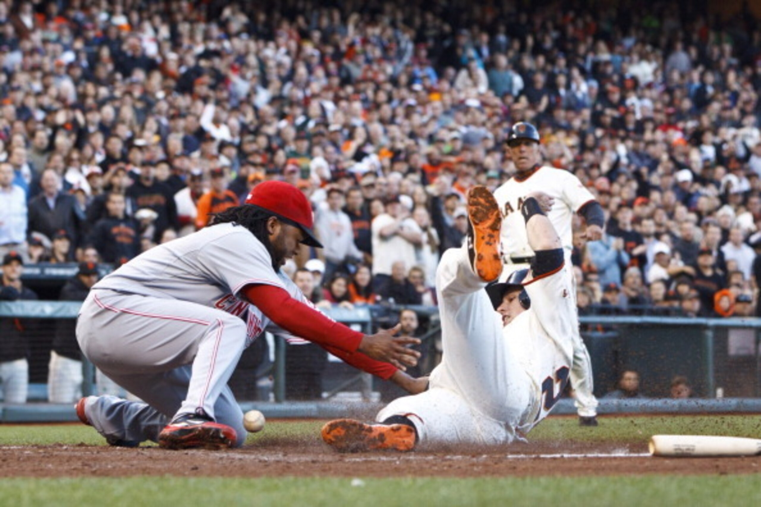 SAN FRANCISCO, CA - JUNE 28: Buster Posey #28 of the San Francisco Giants slides into home for a run ahead of a tag by Johnny Cueto #47 of the Cincinnati Reds during the first inning at AT&T Park on June 28, 2012 in San Francisco, California. (Photo by Ja