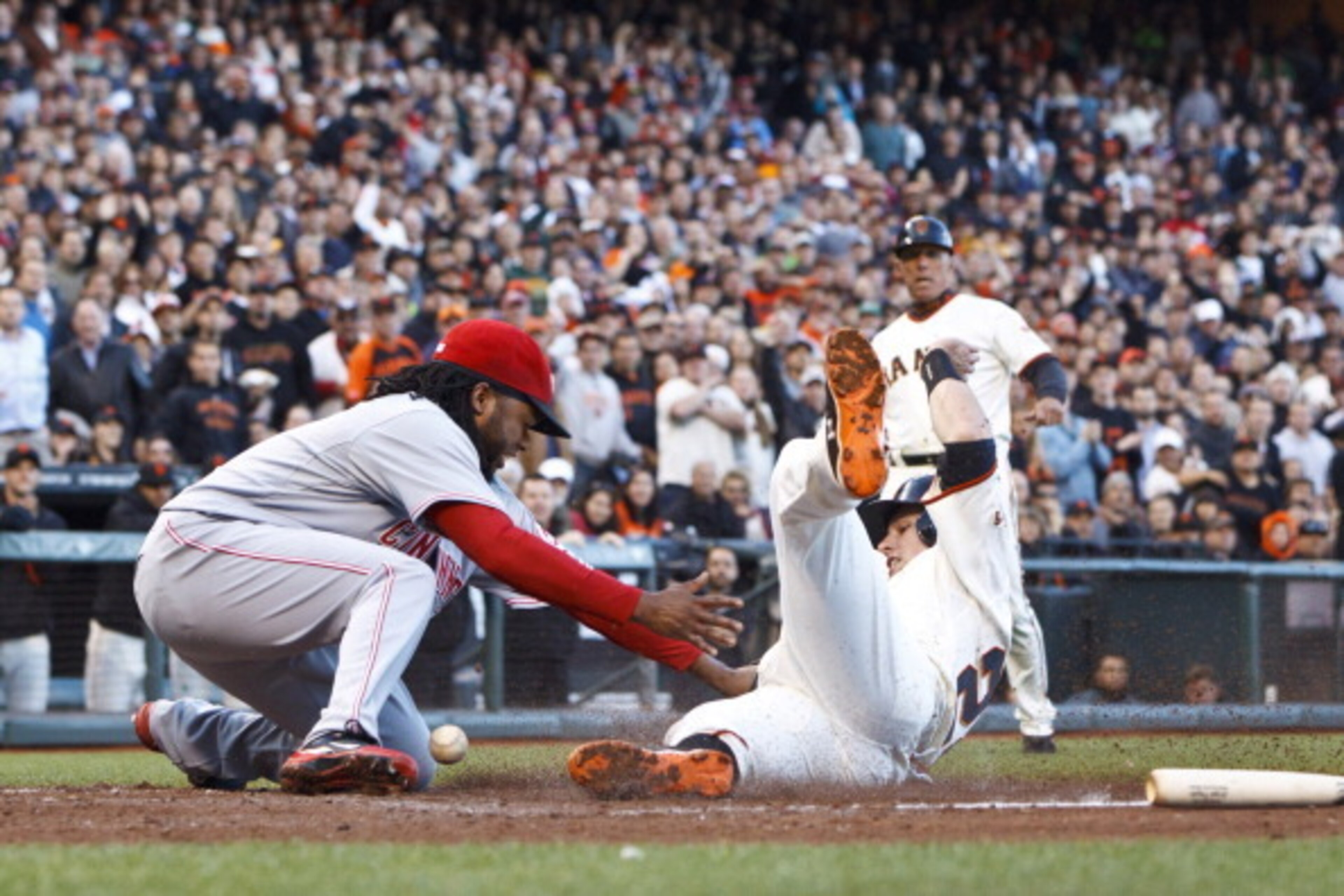 SAN FRANCISCO, CA - JUNE 28: Buster Posey #28 of the San Francisco Giants slides into home for a run ahead of a tag by Johnny Cueto #47 of the Cincinnati Reds during the first inning at AT&T Park on June 28, 2012 in San Francisco, California. (Photo by Ja