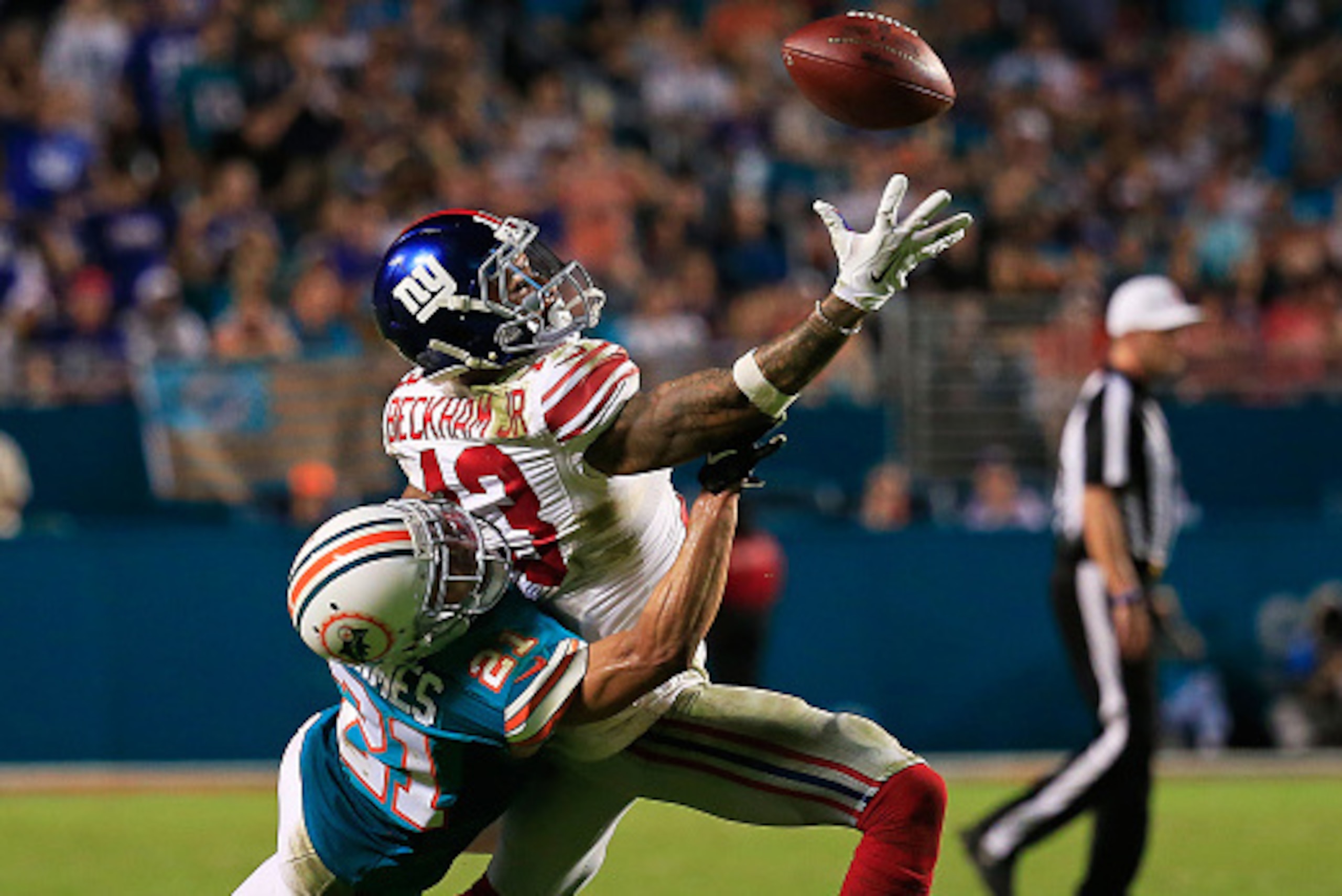 MIAMI GARDENS, FL - DECEMBER 14: Odell Beckham #13 of the New York Giants reaches for the ball while defended by Brent Grimes #21 of the Miami Dolphins during the second half of the game at Sun Life Stadium on December 14, 2015 in Miami Gardens, Florida. MIAMI GARDENS, FL - DECEMBER 14: Odell Beckham #13 of the New York Giants reaches for the ball while defended by Brent Grimes #21 of the Miami Dolphins during the second half of the game at Sun Life Stadium on December 14, 2015 in Miami Gardens, Florida.