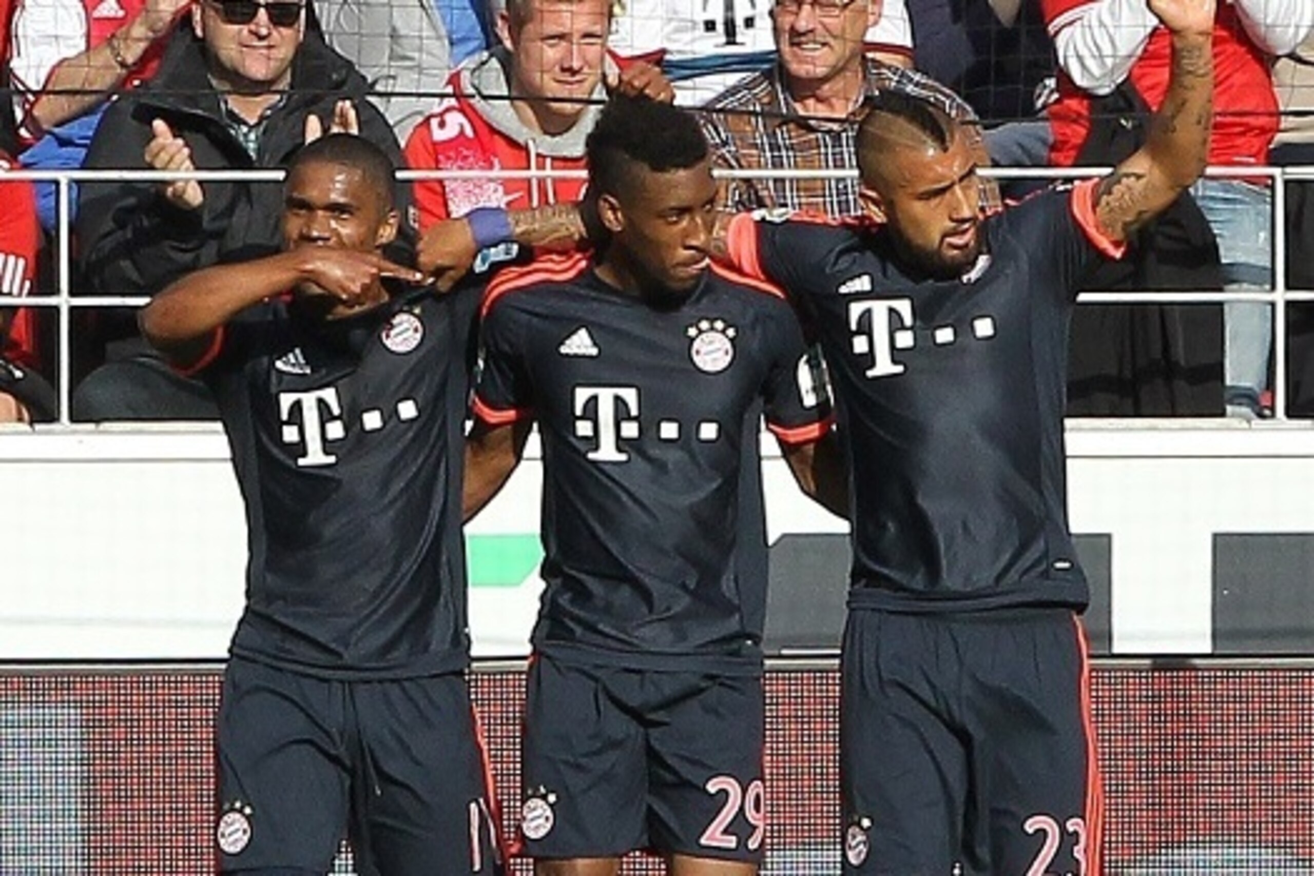 Bayern Munich's French forward Kingsley Coman (L) celebrates scoring the 3-0 with Bayern Munich's Brazilian midfielder Douglas Costa (L) and Bayern Munich's Chilean midfielder Arturo Vidal during the German first division Bundesliga football match 1 FSV M