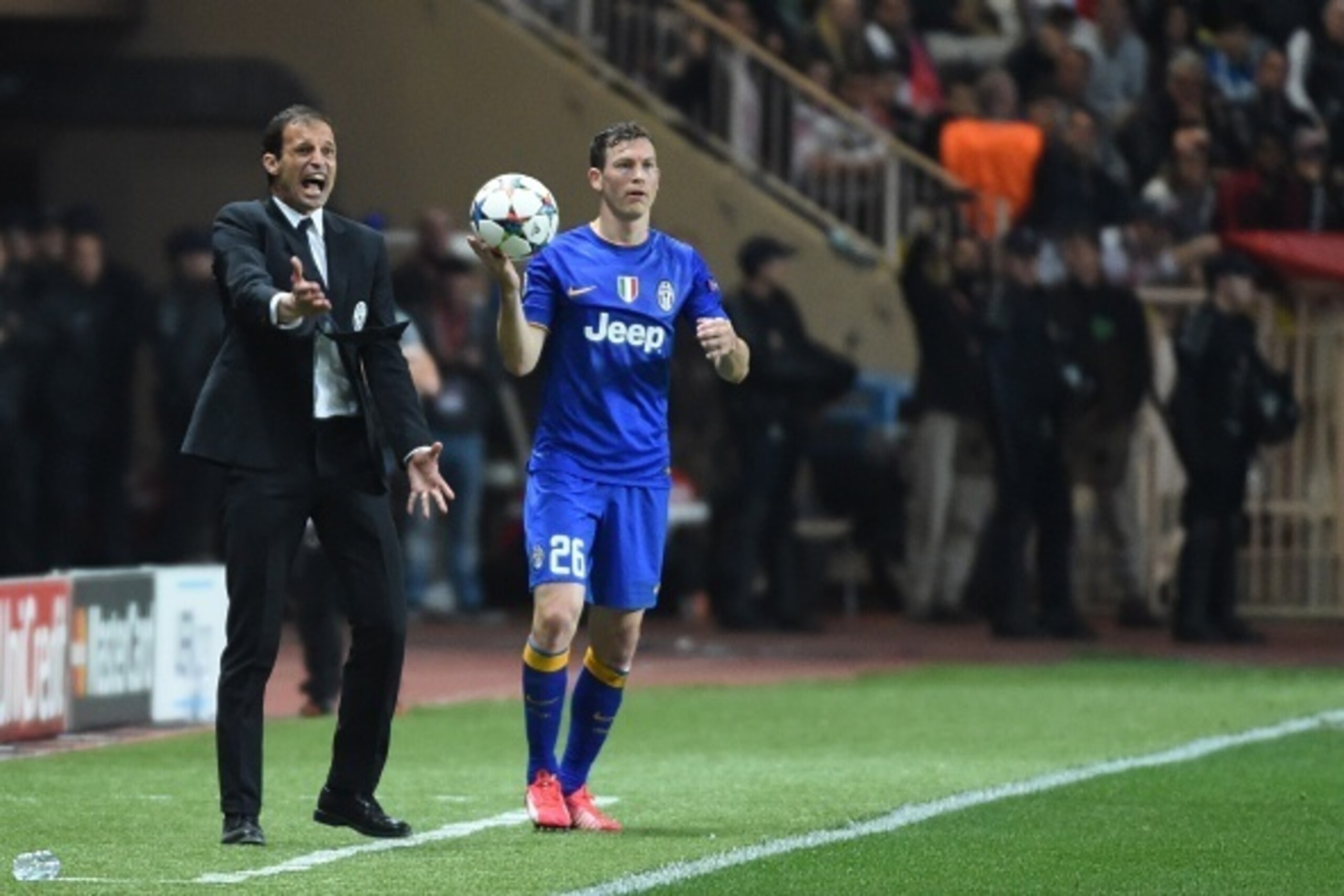 Juventus' coach Massimiliano Allegri (L) reacts as Juventus' defender from Switzerland Stephan Lichtsteiner prepares to throw a line-out during the UEFA Champions League quarter final second leg football match AS Monaco vs Juventus FC on April 22, 2015 at