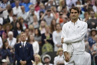 Switzerland's Roger Federer holds the runners-up trophy after losing to Serbia's Novak Djokovic in their men's singles final match, during the presentation on day thirteen of the 2015 Wimbledon Championships at The All England Tennis Club in Wimbledon, so