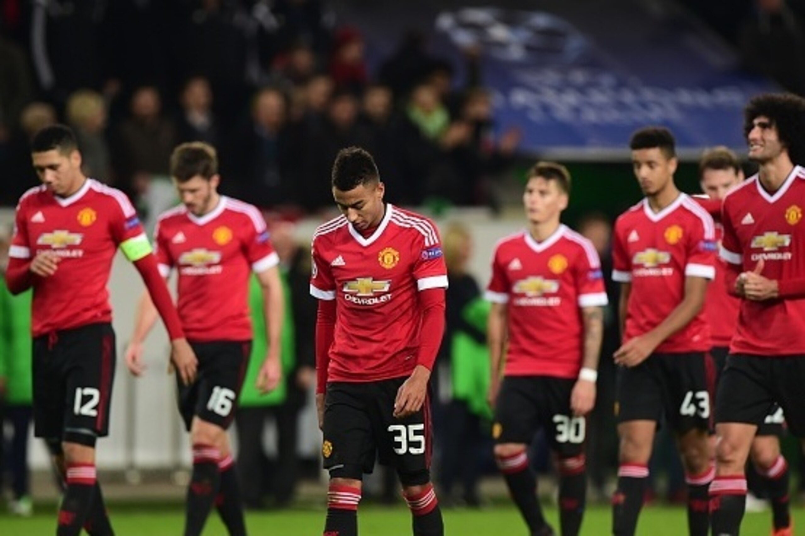 TOPSHOT - Manchester United's players look dejected as they leave the pitch after the UEFA Champions League Group B second-leg football match VfL Wolfsburg vs Manchester United in Wolfsburg, central Germany, on December 8, 2015.  / AFP / JOHN MACDOUGALL  