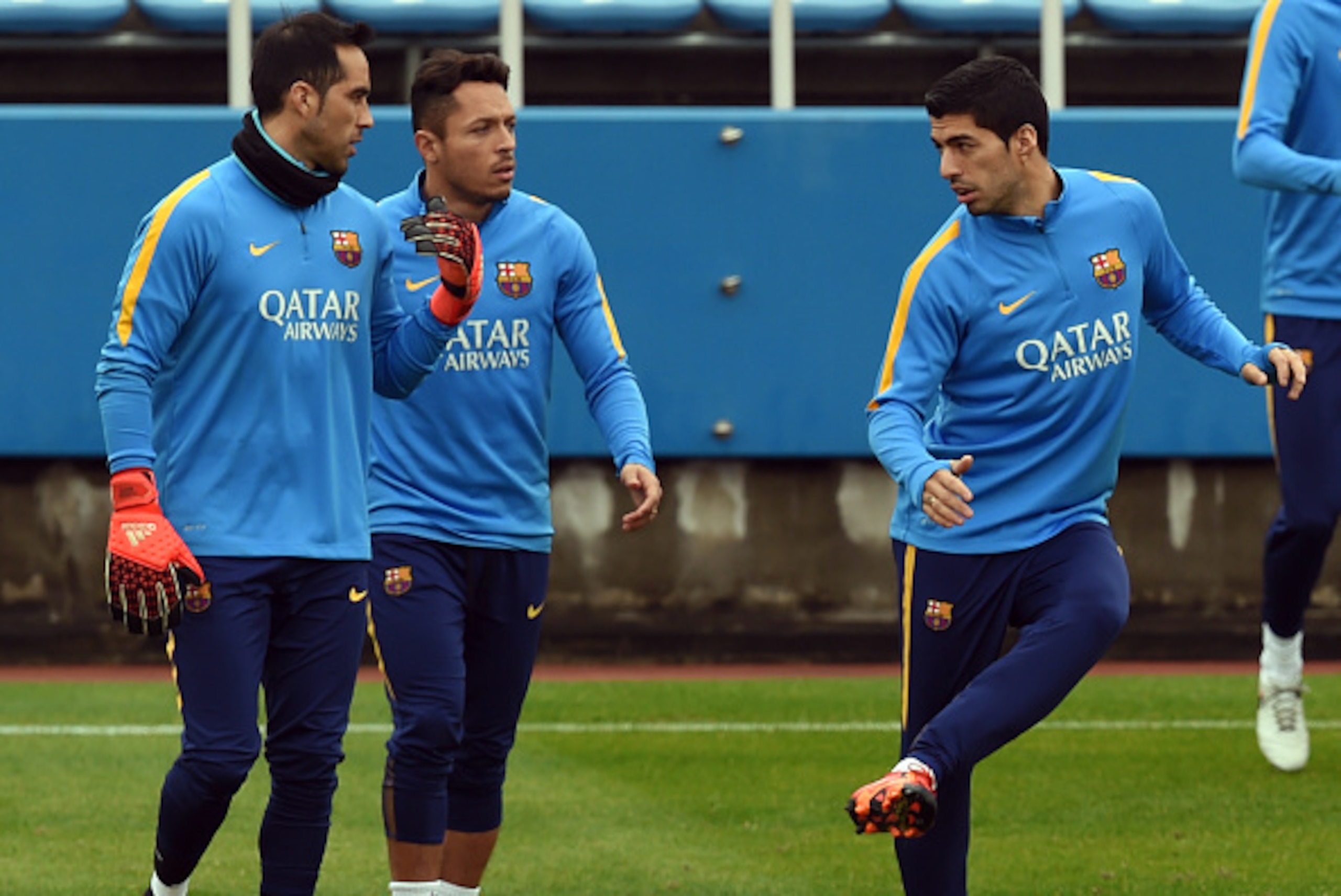 FC Barcelona forward Luis Suarez (R) works out beside defender Adriano (C) and goalkeeper Claudio Bravo (L) during their training session at the Club World Cup football tournament in Yokohama on December 15, 2015. FC Barcelona will play against Asian cham