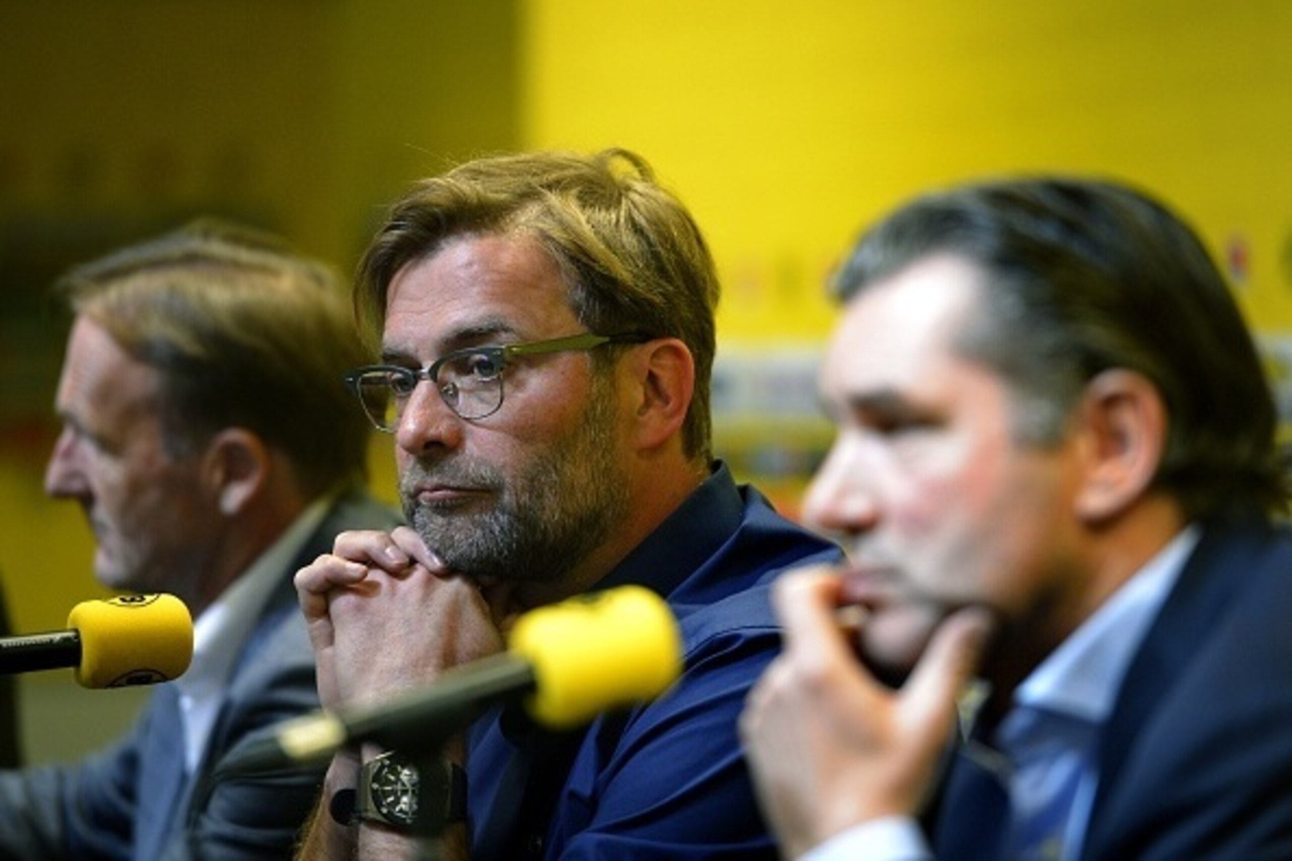 Dortmund's head coach Juergen Klopp (C), Dortmund's CEO Hans-Joachim Watzke (L) and Dormund's sports director Michael Zorc (R) give a press conference on April 15, 2015 in Dortmund, western Germany, to announce that Klopp will step down as coach of German