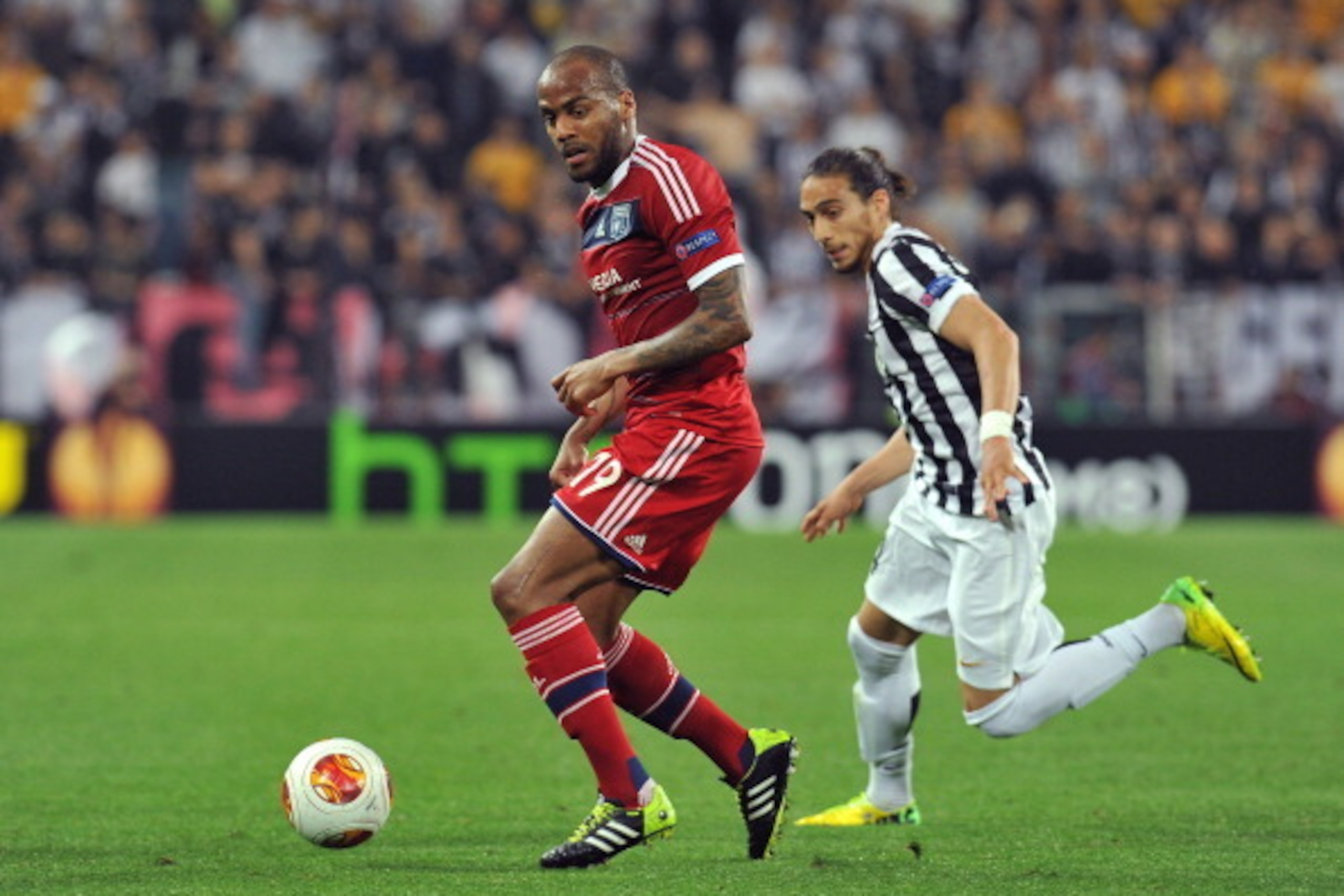 TURIN, ITALY - APRIL 10:  Jimmy Briand (L) of Olympique Lyonnais in action against Martin Caceres of Juventus
during the UEFA Europa League quarter final match between Juventus and Olympique Lyonnais at Juventus Arena on April 10, 2014 in Turin, Italy.  (