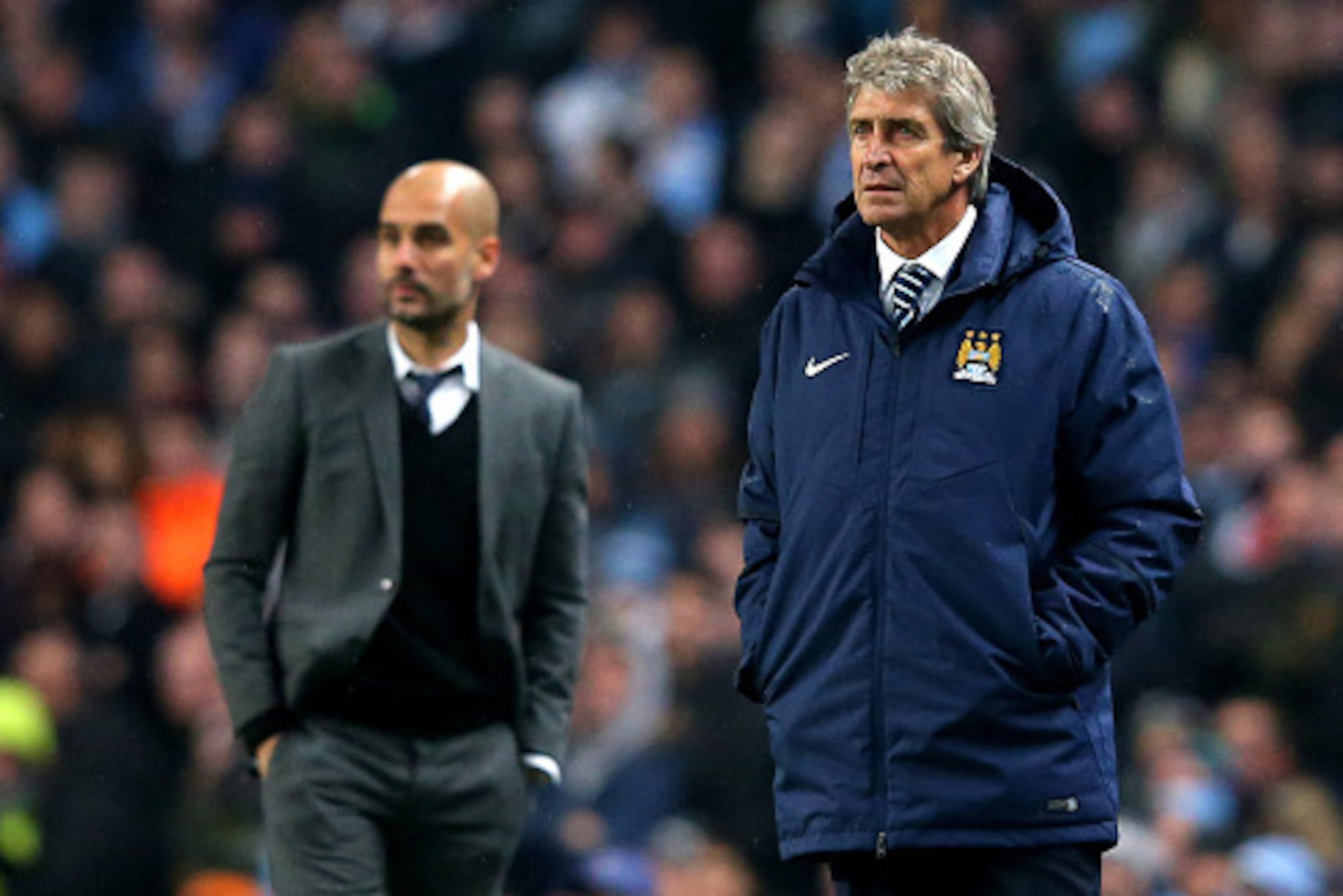 MANCHESTER, ENGLAND - NOVEMBER 25:  (R-L) Manuel Pellegrini the manager of Manchester City and Josep Guardiola the head coach of Bayern Muenchen look on during the UEFA Champions League Group E match between Manchester City and FC Bayern Muenchen at the E