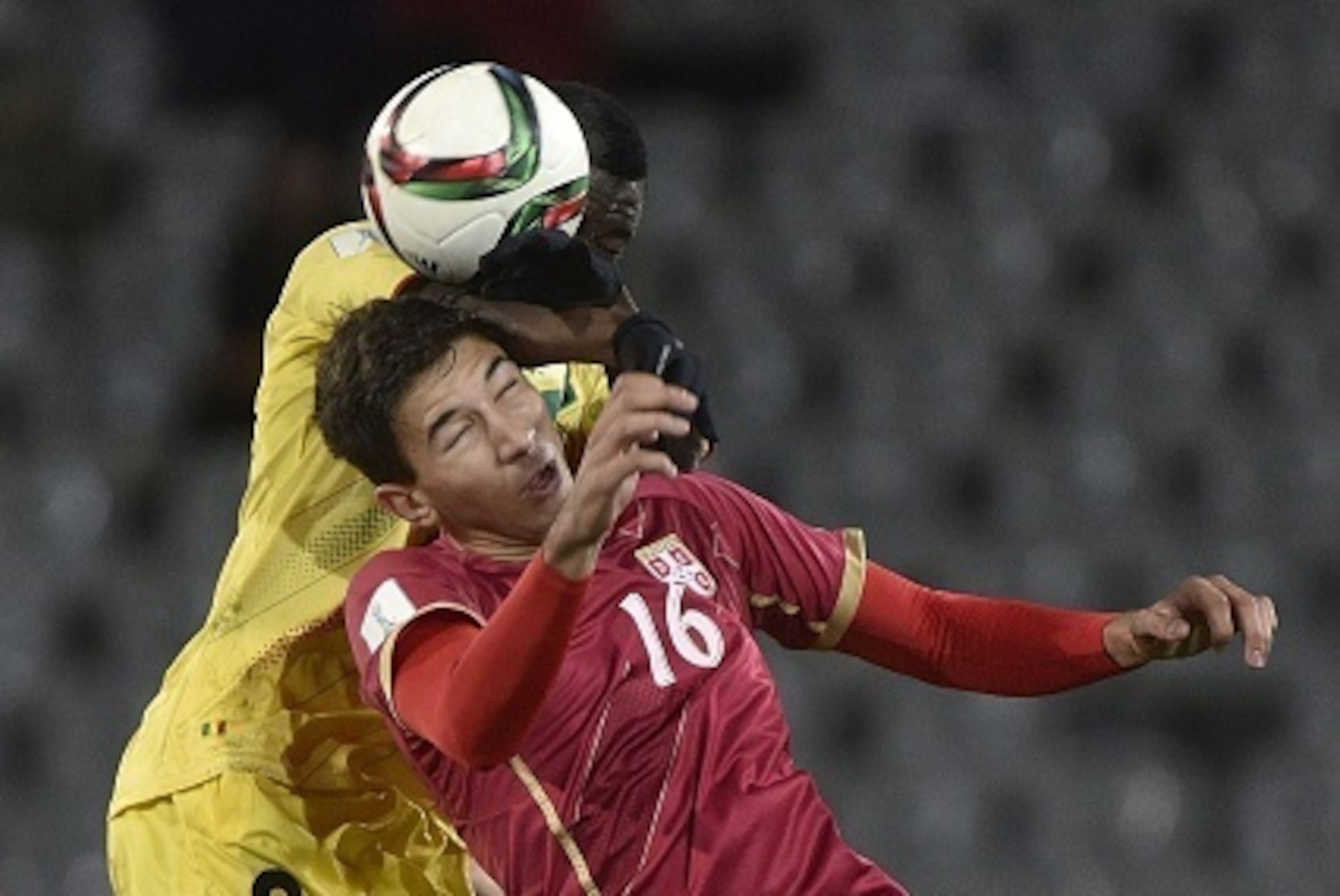Marko Grujic (front) of Serbia jumps for the ball with Diadie Samassekou of Mali (back L) during the FIFA Under-20 World Cup football match between Serbia and Mali at Otago Regional Stadium in Dunedin on June 3, 2015.     AFP PHOTO / MARTY MELVILLE       
