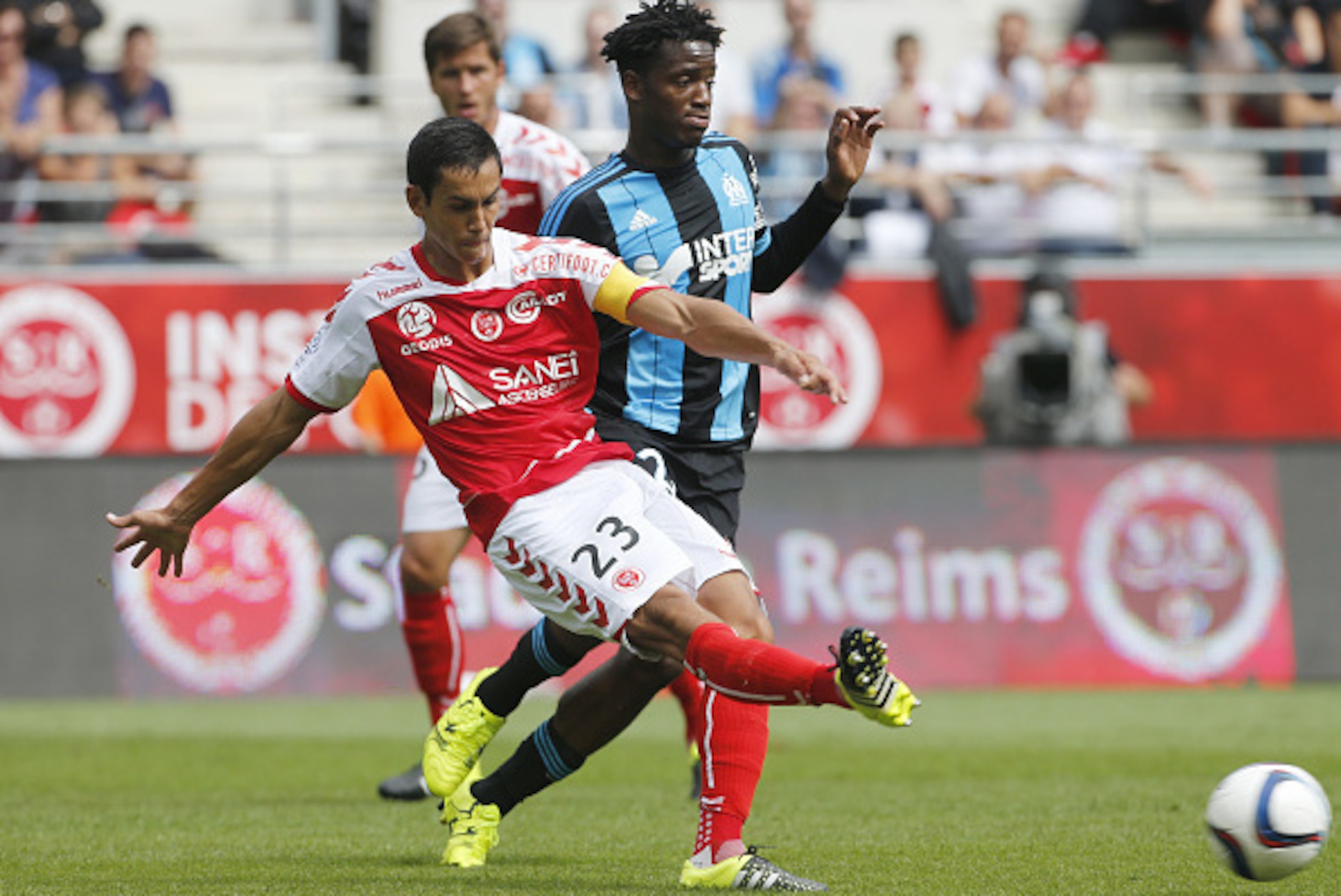 REIMS - AUGUST 16: Aissa Mandi of Stade de Reims and Michy Batshuayi of OM in action during the French Ligue 1 match between Stade de Reims and Olympique de Marseille (OM) at Stade Auguste Delaune on August 16, 2015 in Reims, France. (Photo by Jean Catuff