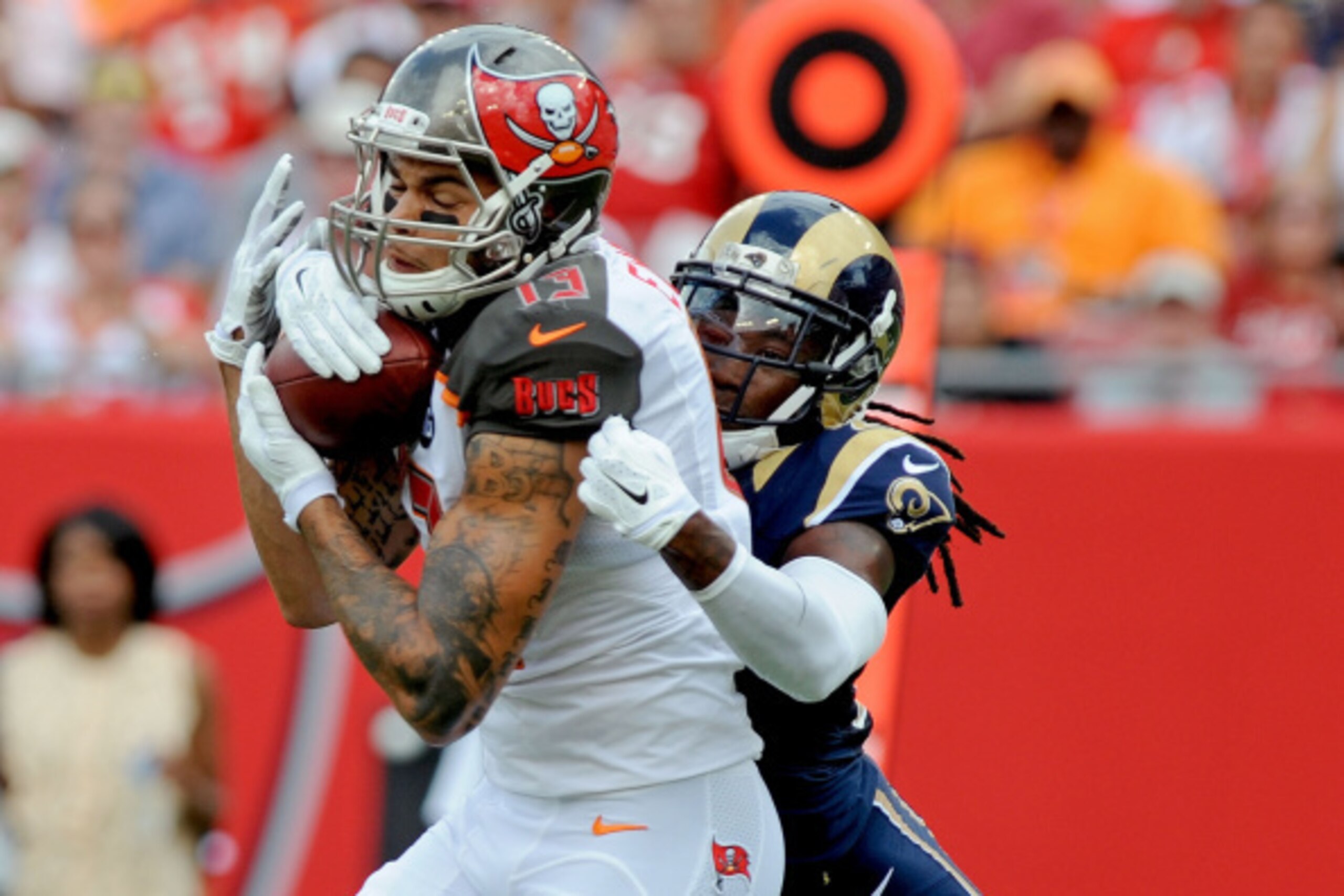 TAMPA, FL - SEPTEMBER 14: Mike Evans #13 of the Tampa Bay Buccaneers catches the ball as Janoris Jenkins #21 of the St. Louis Rams defends during the first quarter of the game at Raymond James Stadium on September 14, 2014 in Tampa, Florida.  (Photo by Cl