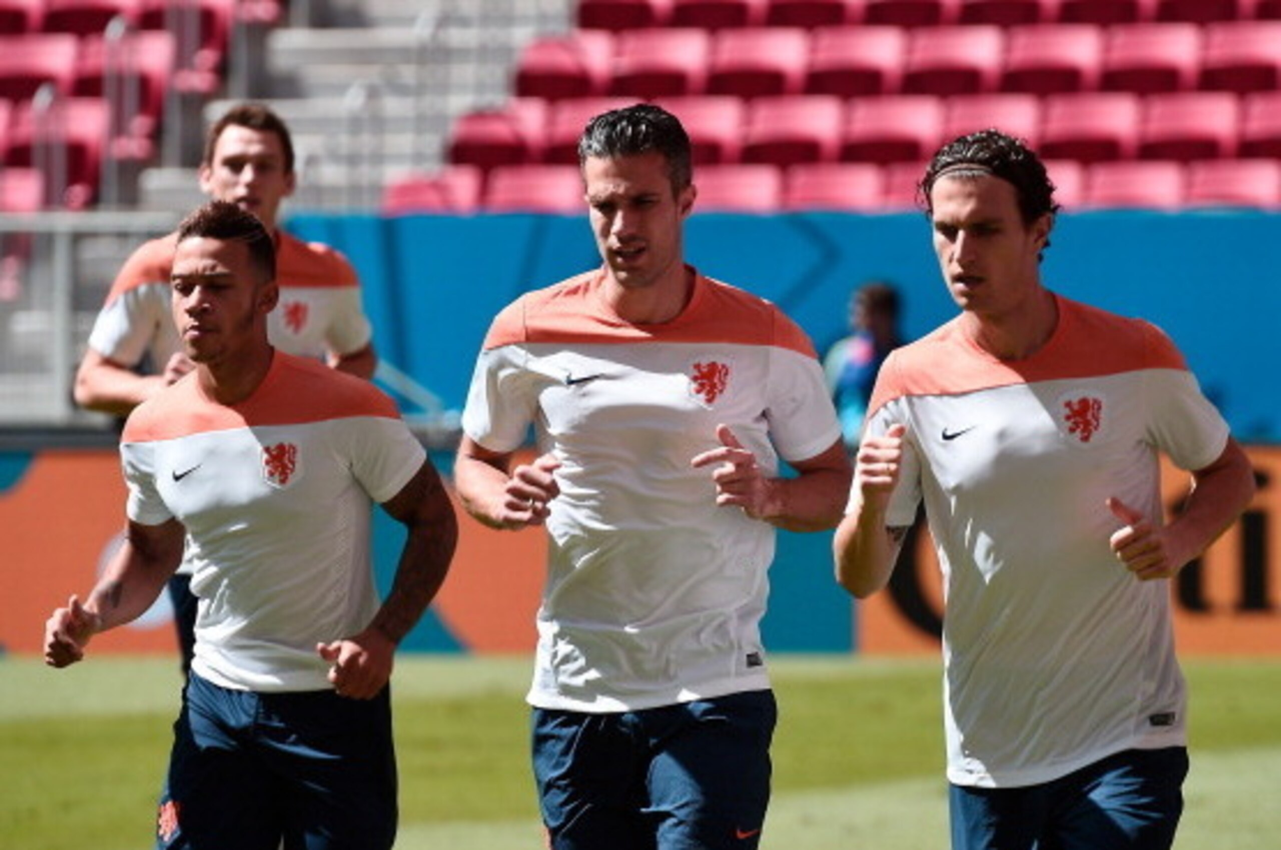 (L-R) Netherlands' forward Memphis Depay, Netherlands' forward and captain Robin van Persie and Netherlands' defender Daryl Janmaat run during a training session at the National Stadium in Brasilia on July 11, 2014 on the eve of the 2014 FIFA World Cup fo