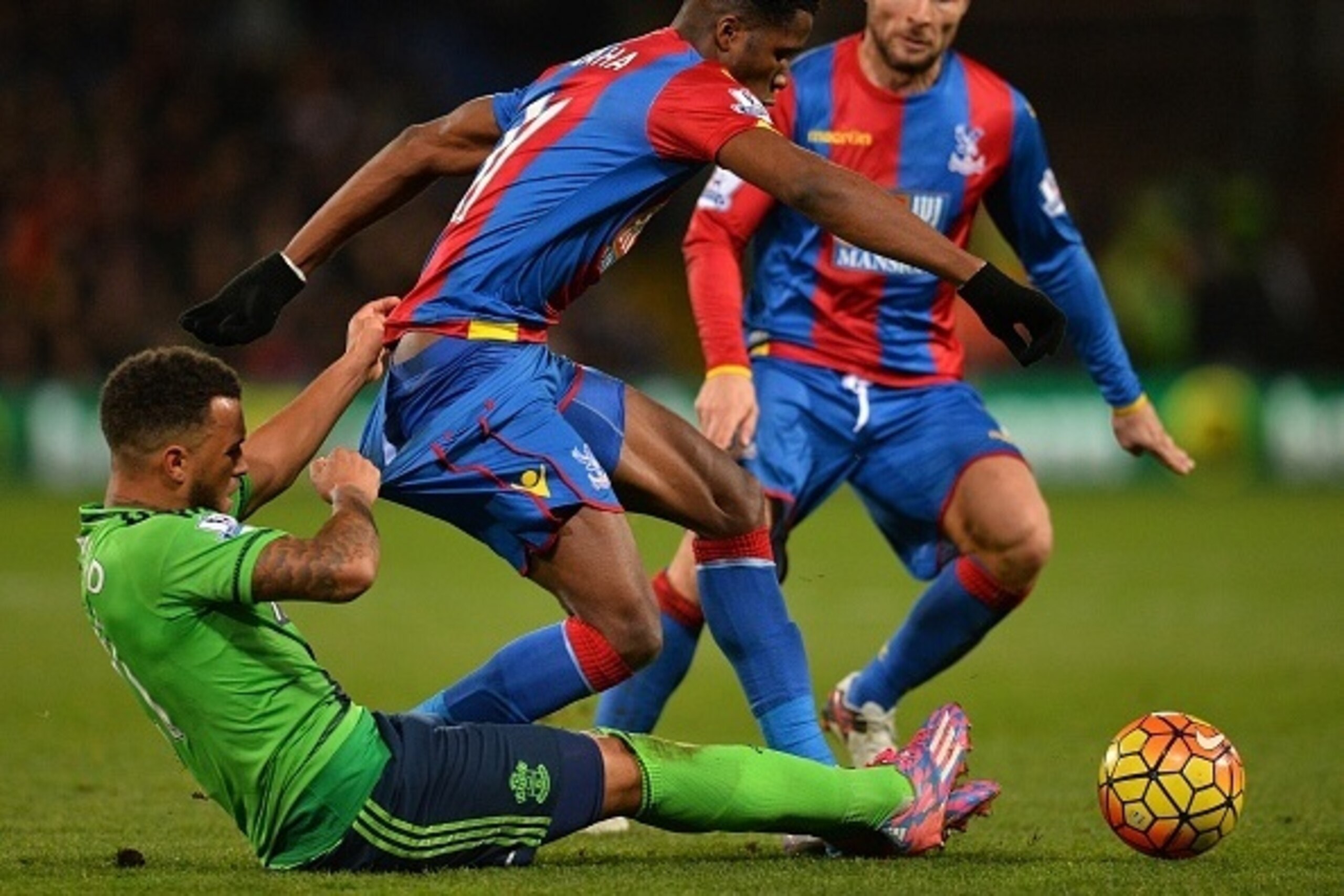 Crystal Palace's Ivorian-born English striker Wilfried Zaha (C) vies with Southampton's English defender Ryan Bertrand (L) during the English Premier League football match between Crystal Palace and Southampton at Selhurst Park in south London on December