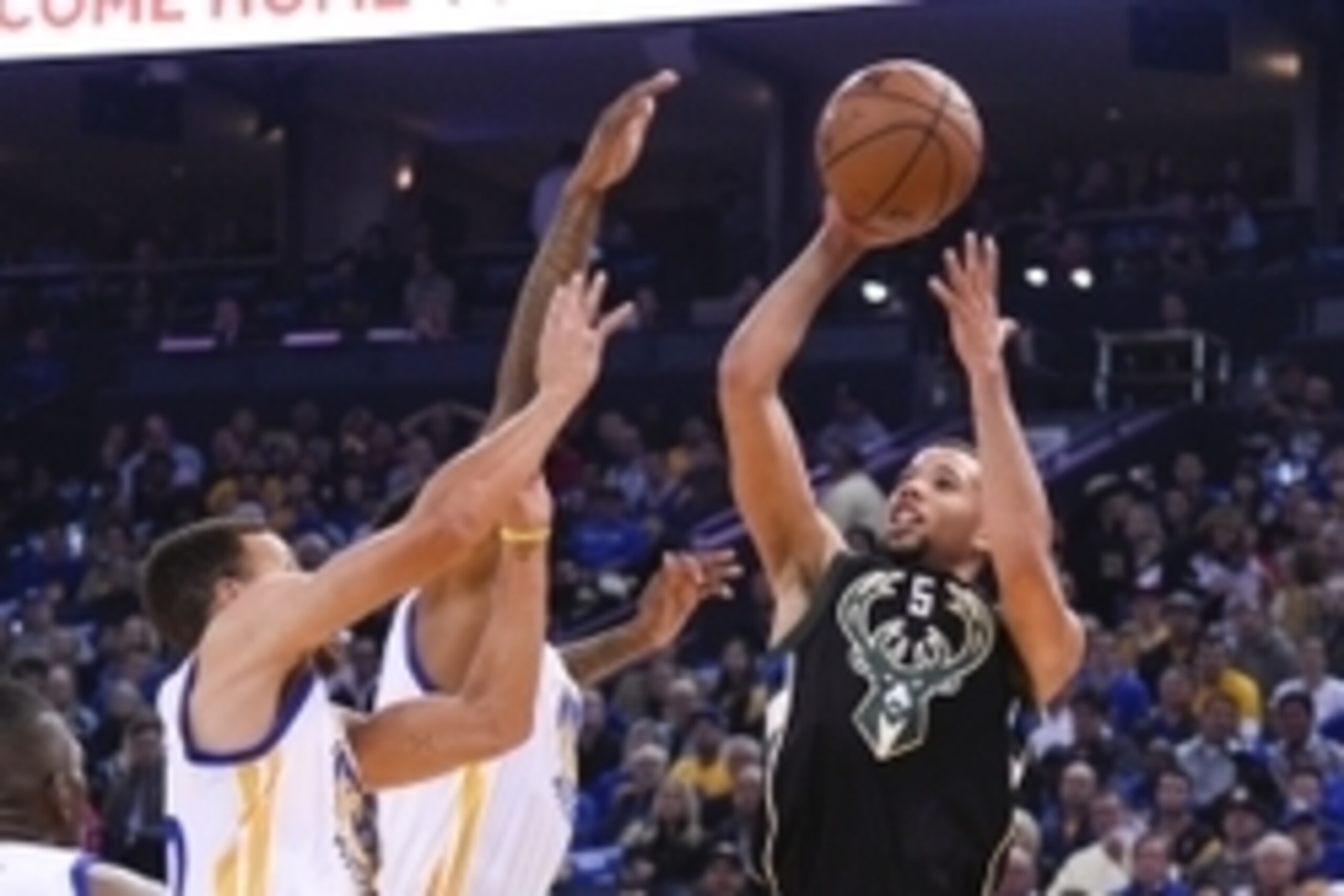 December 18, 2015; Oakland, CA, USA; Milwaukee Bucks guard Michael Carter-Williams (5) shoots the basketball against Golden State Warriors guard Stephen Curry (30, left) and forward Brandon Rush (4, center) during the first quarter at Oracle Arena. Mandat
