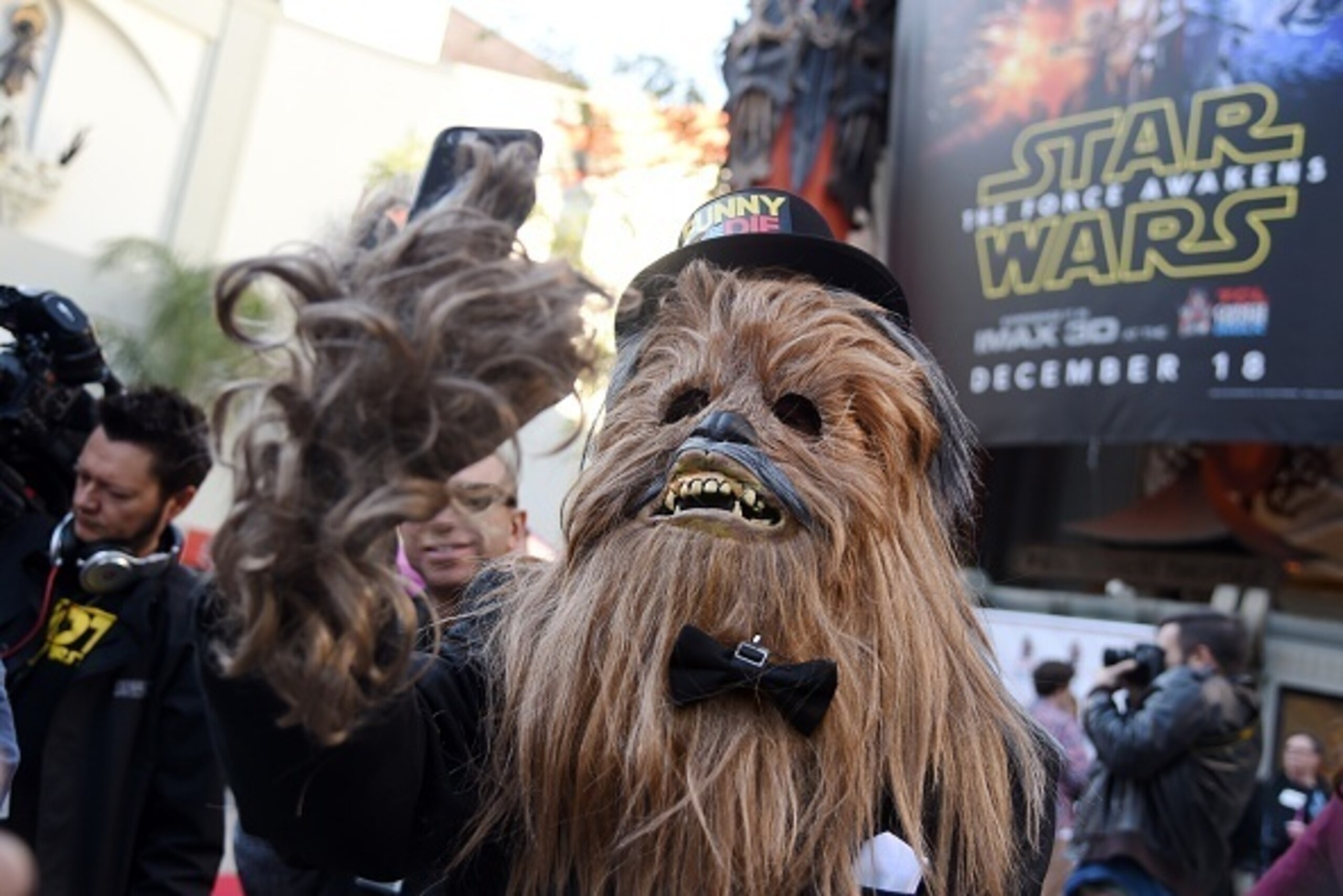TOPSHOT - A man in a Chewbacca costume takes a selfie in front of the TCL Chinese Theatre, December 17, 2015 in Hollywood, California.  The Chewbacca was a member of the wedding party for Australian two 'Star Wars' fans who were married in a 'Star Wars'-t