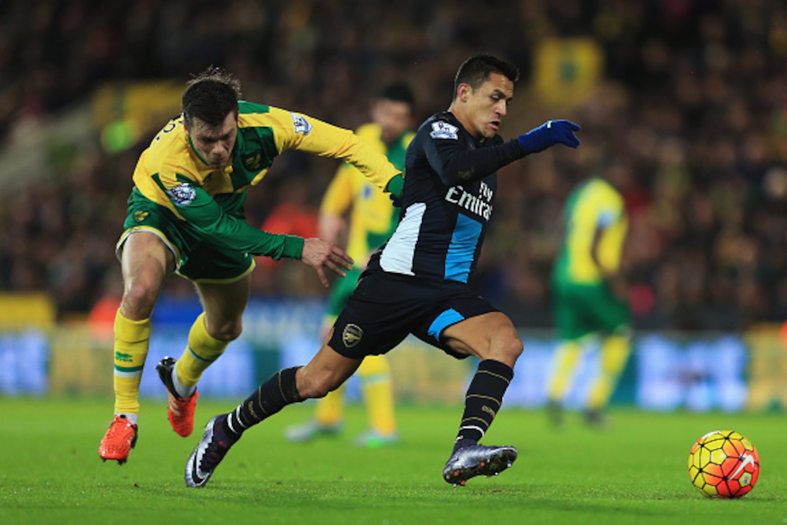 NORWICH, ENGLAND - NOVEMBER 29:  Alexis Sanchez of Arsenal evades Jonathan Howson of Norwich City during the Barclays Premier League match between Norwich City and Arsenal at Carrow Road on November 29, 2015 in Norwich, England.  (Photo by Stephen Pond/Ge