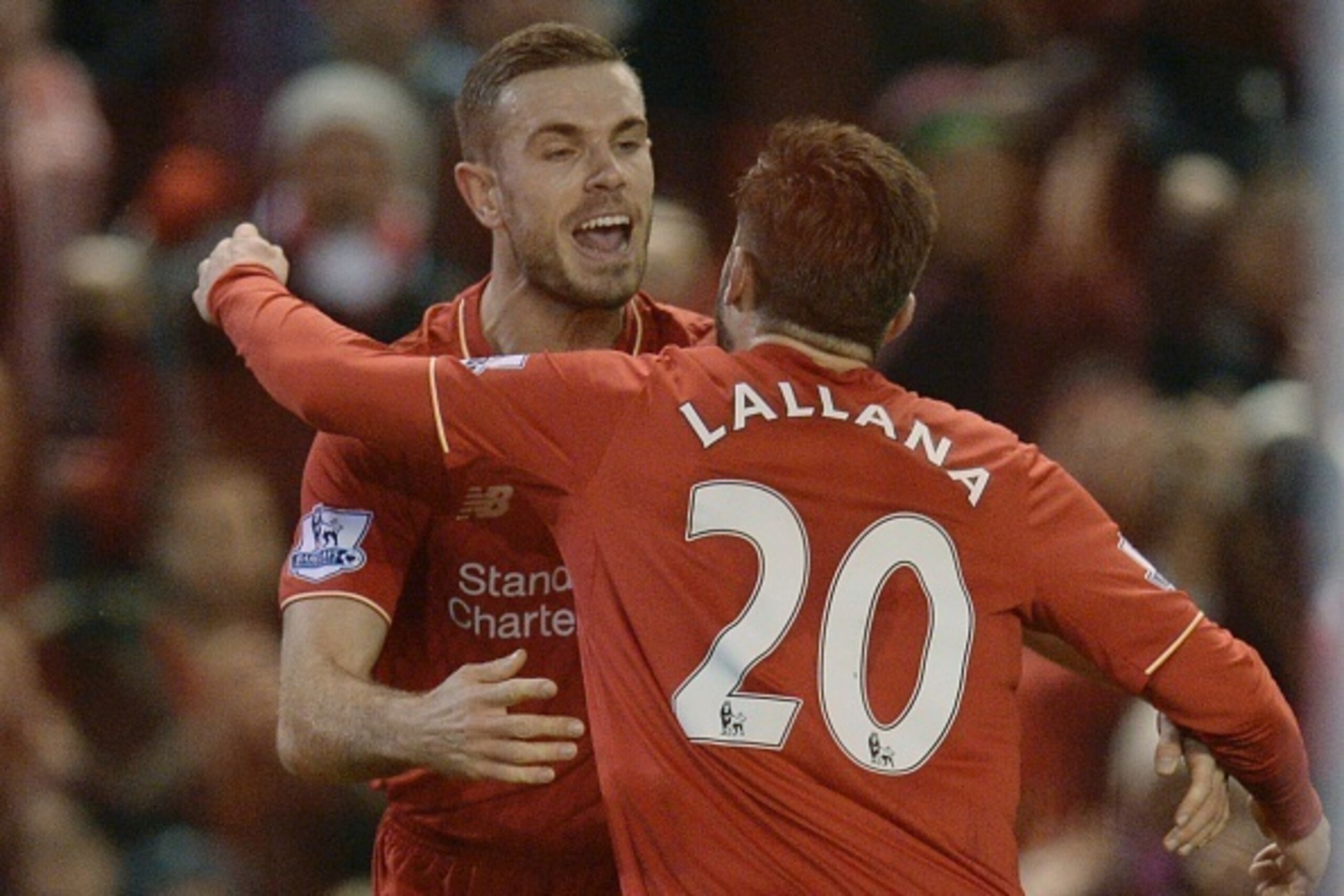 Liverpool's English midfielder Jordan Henderson (L) celebrates with Liverpool's English midfielder Adam Lallana (R) after scoring the opening goal during the English Premier League football match between Liverpool and West Bromwich Albion at Anfield in Li
