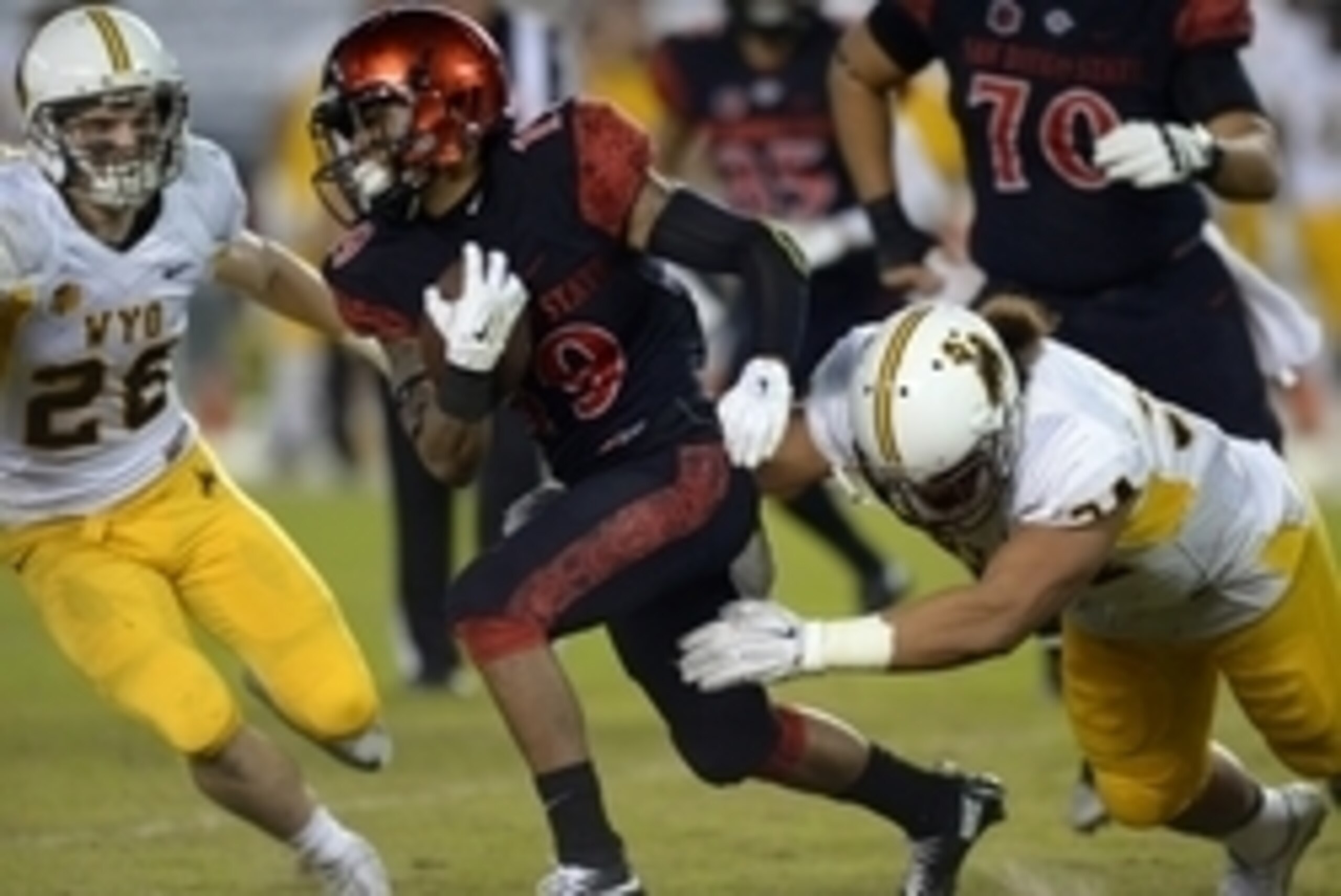 Nov 14, 2015; San Diego, CA, USA; San Diego State Aztecs running back Donnel Pumphrey (19) is defended by Wyoming Cowboys defensive end Siaosi Hala'api'api (right) and cornerback C.J. Jennings (26) during the second quarter at Qualcomm Stadium. Mandatory