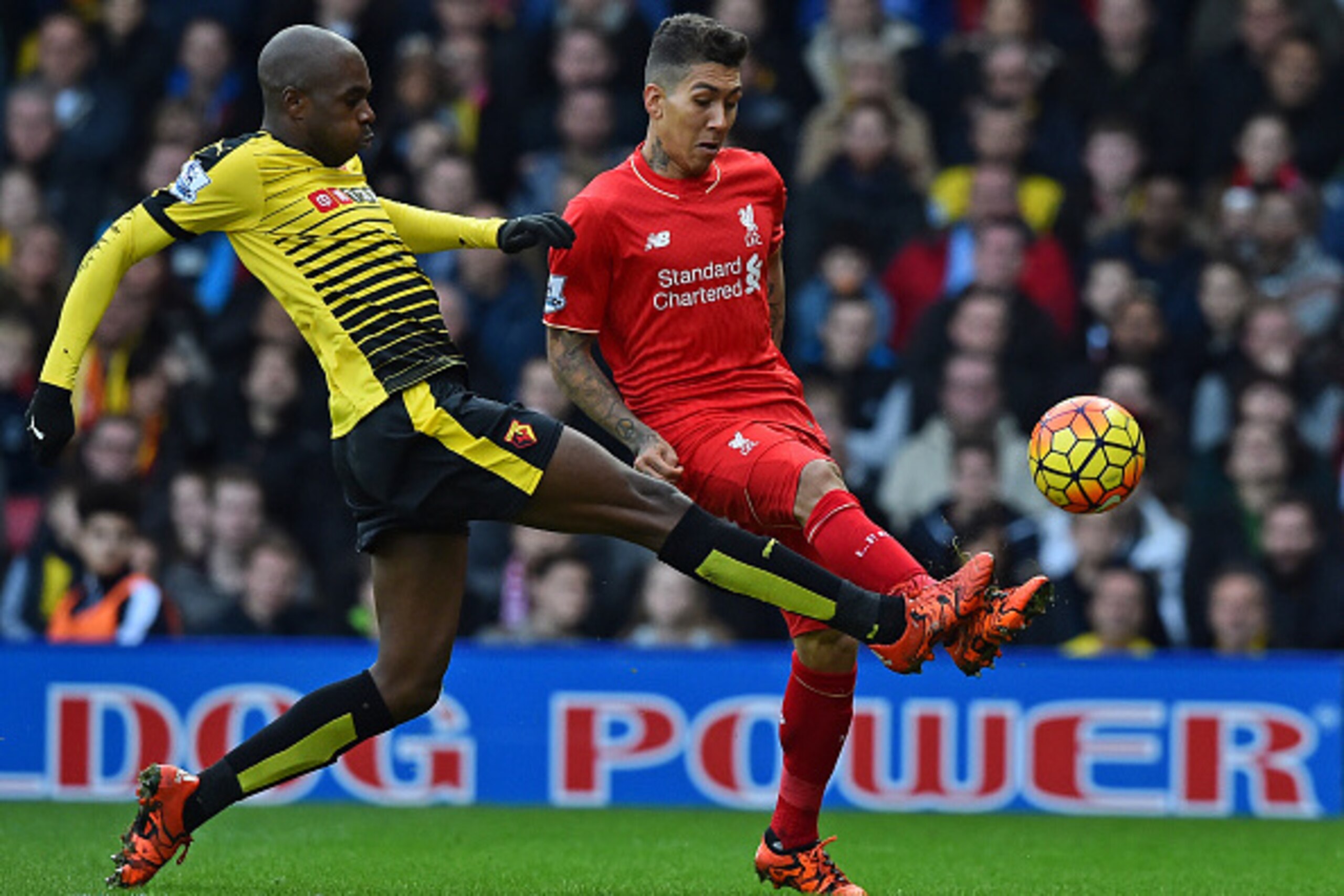 Liverpool's Brazilian midfielder Roberto Firmino (R) has an unsuccessful attempt on goal as Watford's Cameroonian defender Allan Nyom (L) makes a challenge during the English Premier League football match between Watford and Liverpool at Vicarage Road Sta