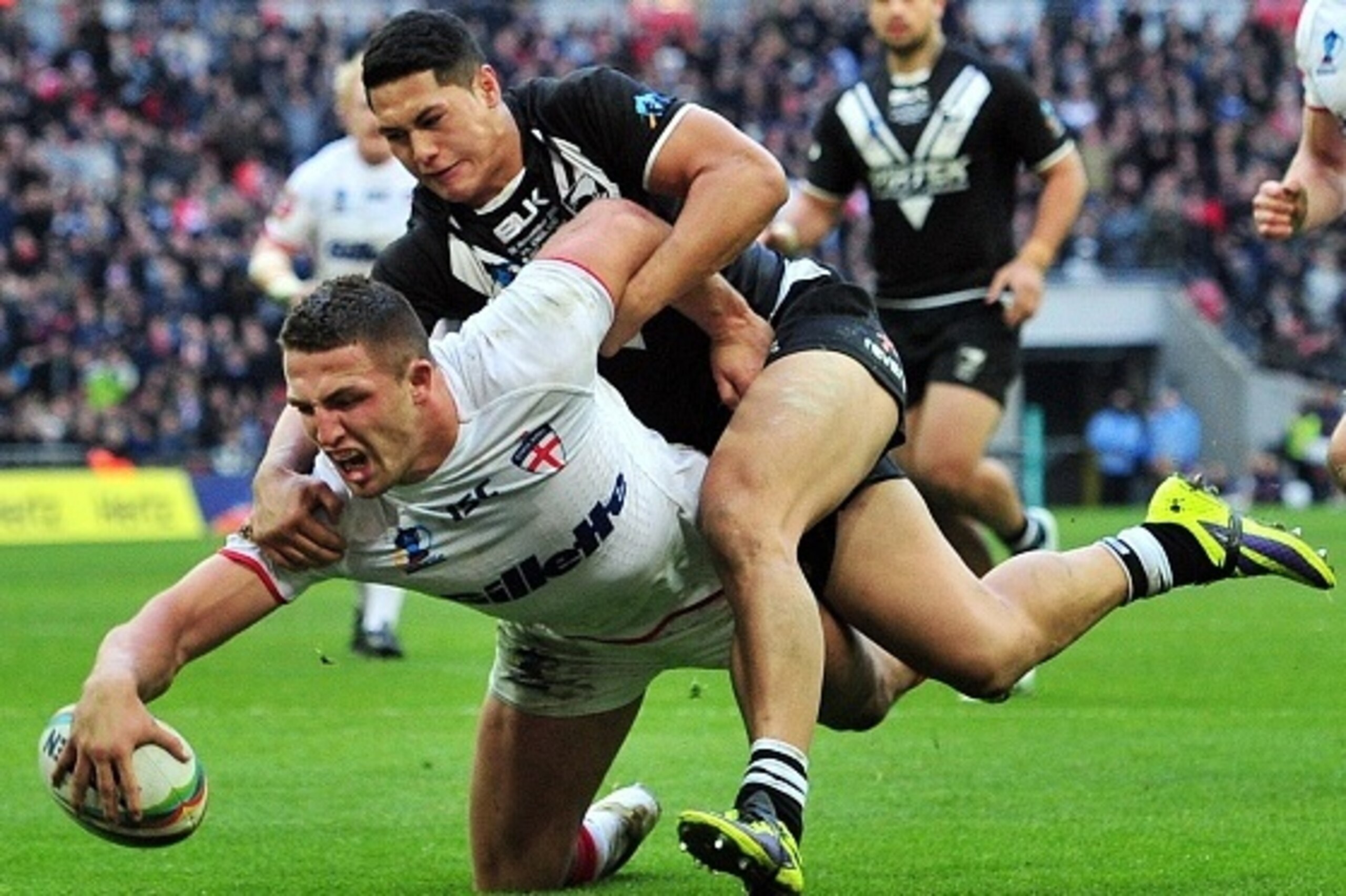 England's Sam Burgess (L) scores a try during the 2013 Rugby League World Cup semi-final match between England and New Zealand at Wembley Stadium in London on November 23, 2013. AFP PHOTO / GLYN KIRK        (Photo credit should read GLYN KIRK/AFP/Getty Im