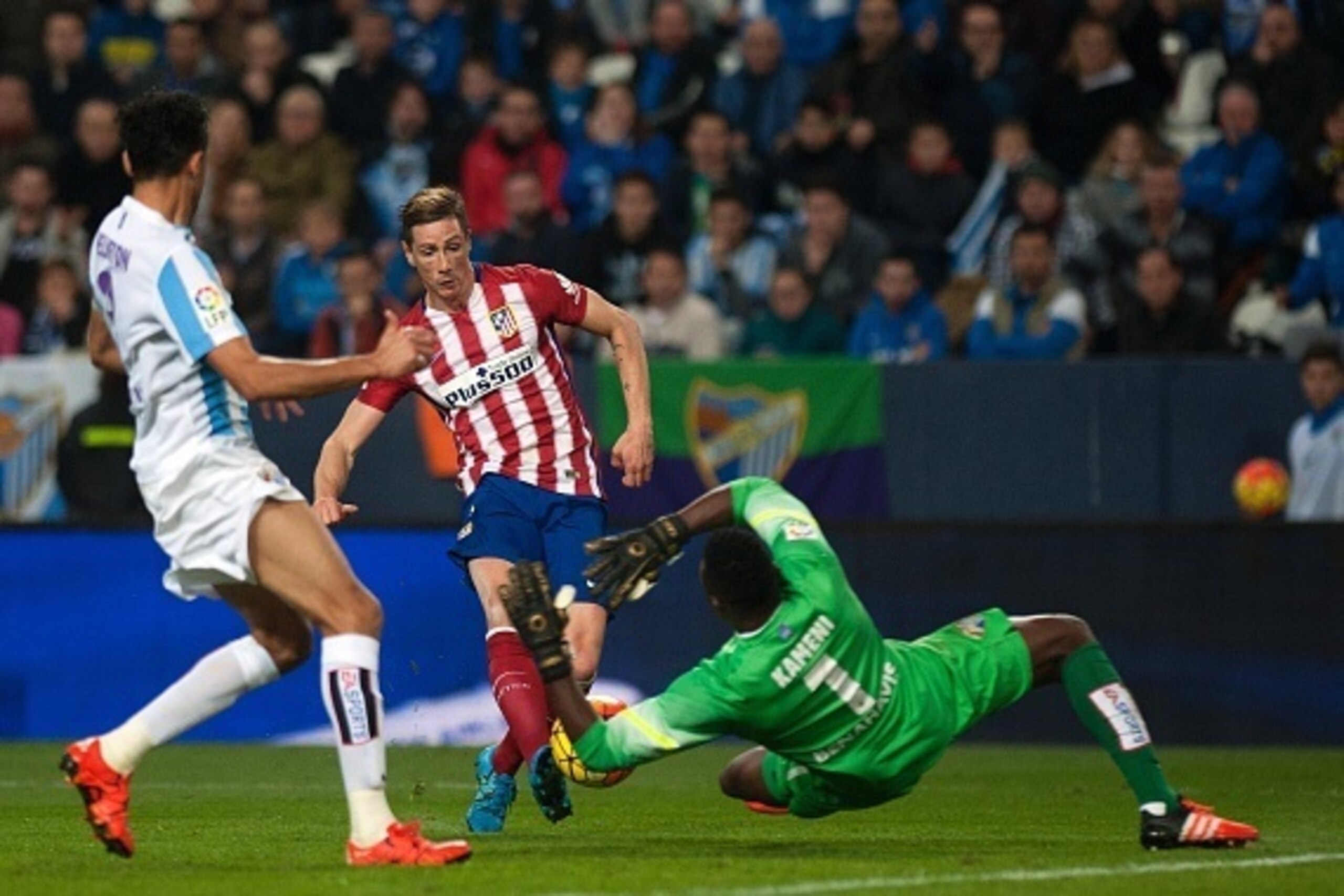 Atletico Madrid's forward Fernando Torres (C) shoots against Malaga's Cameroonian goalkeeper Carlos Kameni during the Spanish league football match Malaga CF vs Club Atletico de Madrid at La Rosaleda stadium in Malaga on December 20, 2015.   AFP PHOTO / J