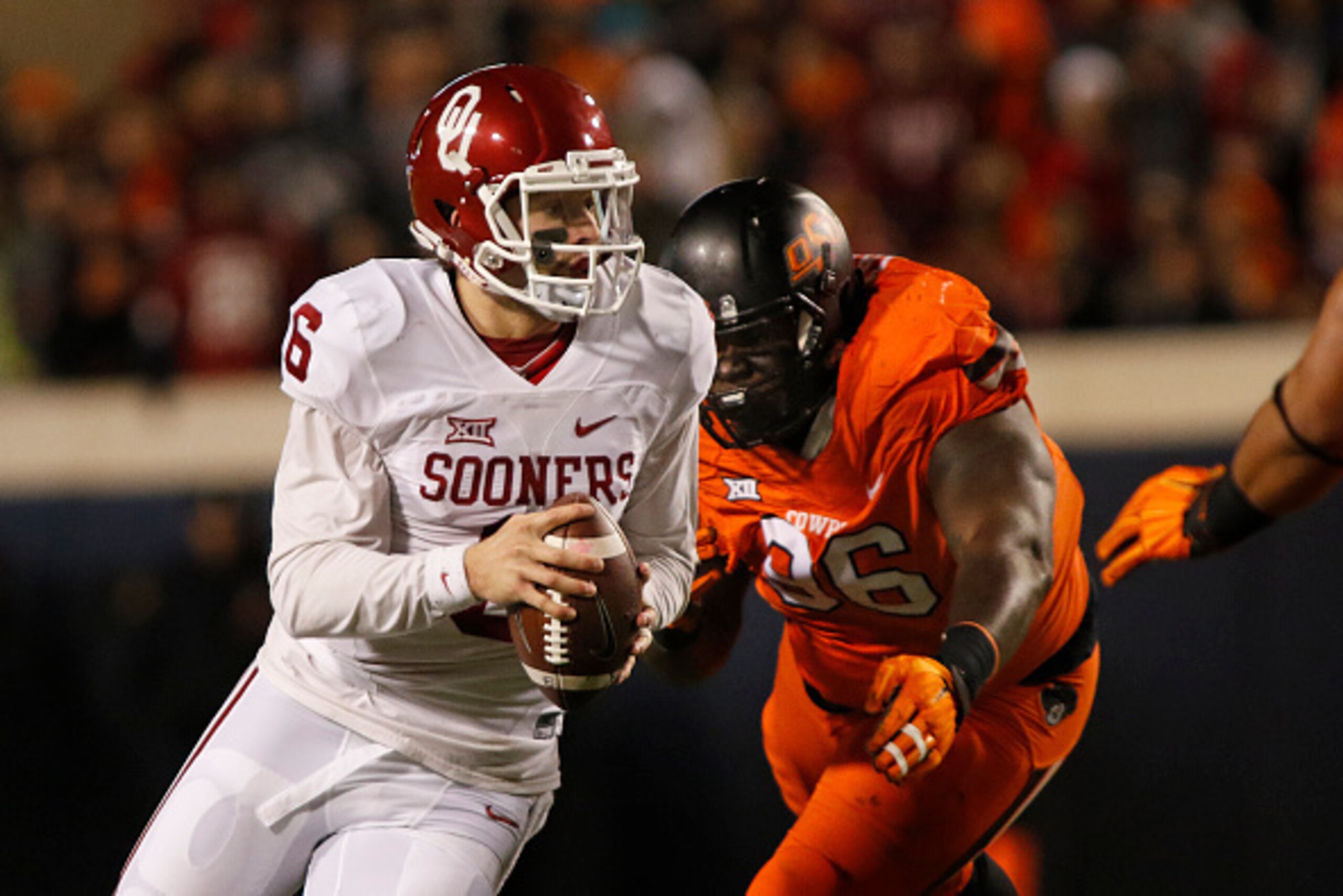 STILLWATER, OK - NOVEMBER 28 : Quarterback Baker Mayfield #6 of the Oklahoma Sooners scrambles under pressure from defensive tackle Vincent Taylor #96 of the Oklahoma State Cowboys November 28, 2015 at Boone Pickens Stadium in Stillwater, Oklahoma. Oklaho