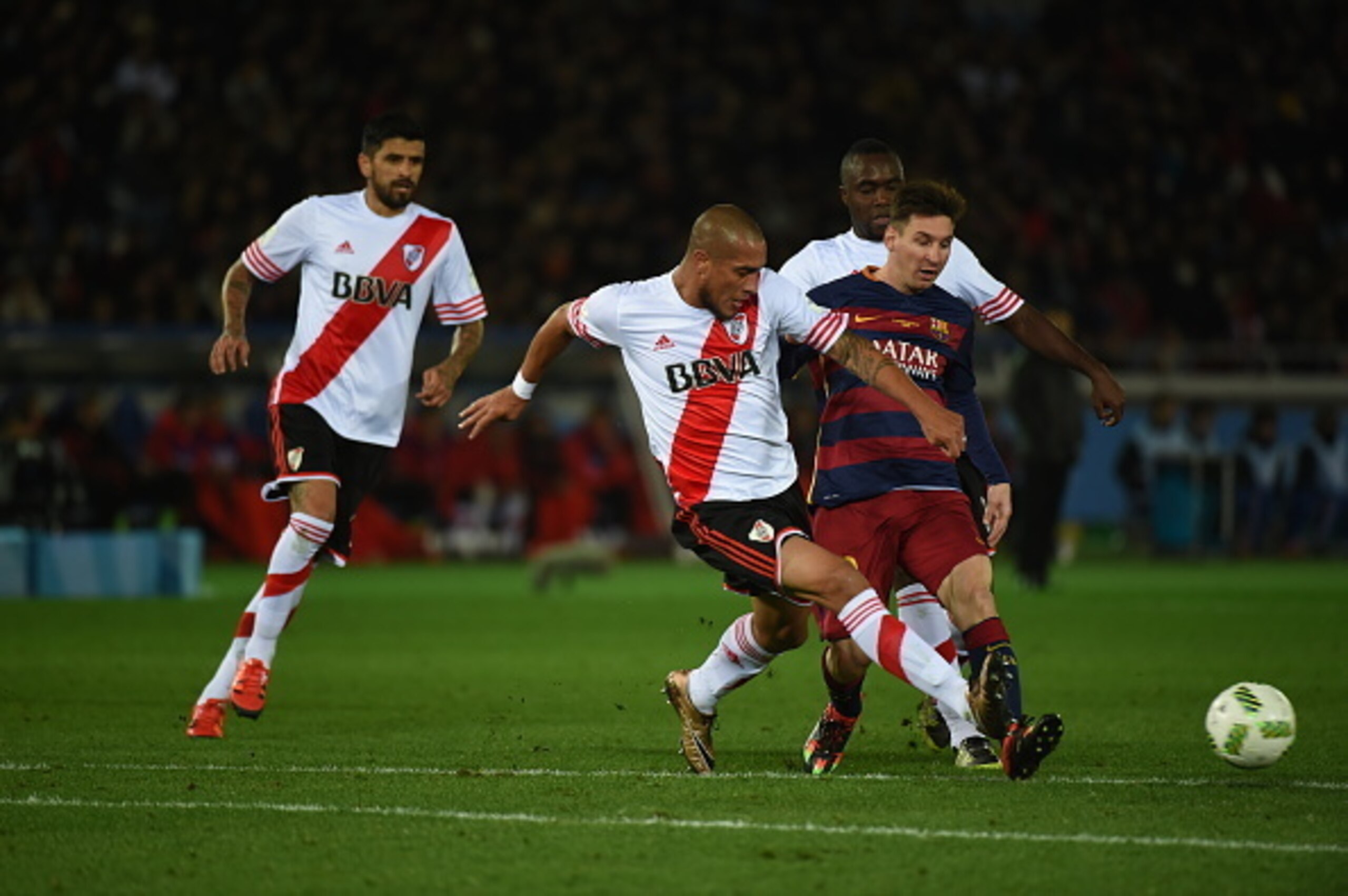 YOKOHAMA, JAPAN - DECEMBER 20:  Lionel Messi of FC Barcelona passes under the challenge from Jonatan Maidana of River Plate during the FIFA Club World Cup Final match between River Plate and FC Barceloan at International Stadium Yokohama on December 20, 2