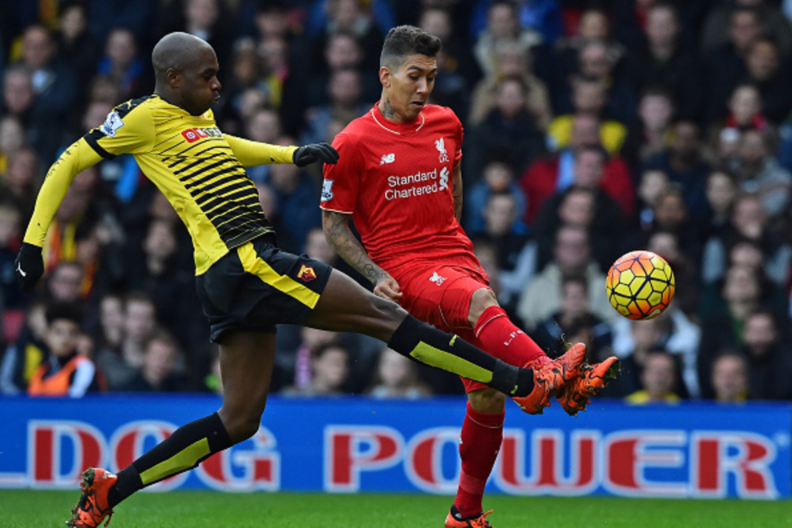 Liverpool's Brazilian midfielder Roberto Firmino (R) has an unsuccessful attempt on goal as Watford's Cameroonian defender Allan Nyom (L) makes a challenge during the English Premier League football match between Watford and Liverpool at Vicarage Road Sta