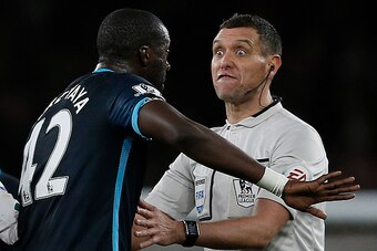English referee Andre Marriner (R) reacts as he talks with Manchester City's Ivorian midfielder and captain Yaya Toure following his challenge on Arsenal's French striker Olivier Giroud (not pictiured), during the English Premier League football match bet