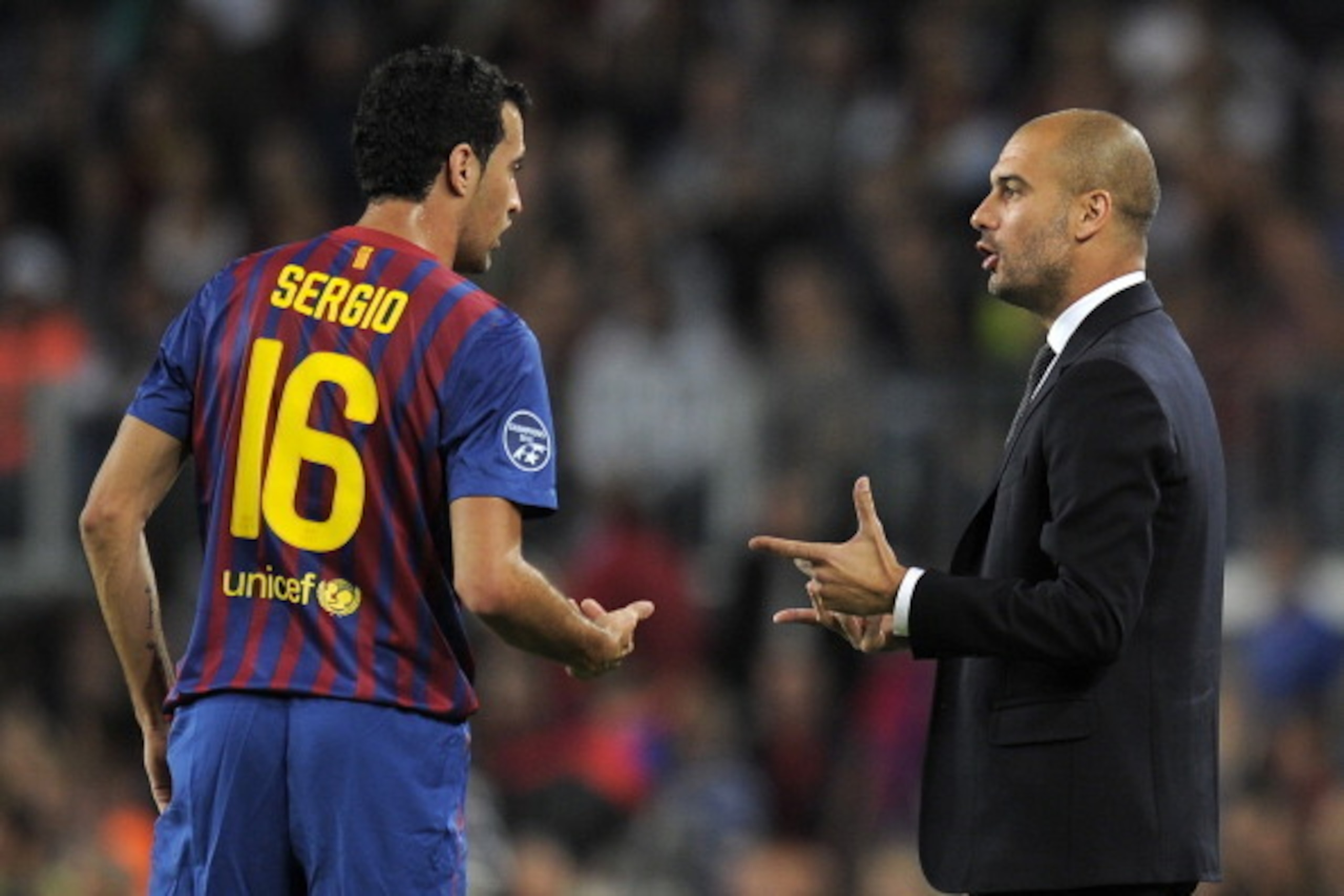 Barcelona's coach Josep Guardiola (R) talks with Barcelona's midfielder Sergio Busquets (L) during the Champions League football match between FC Barcelona and Viktoria Plzen at the Camp Nou stadium in Barcelona on October 19, 2011. AFP PHOTO/LLUIS GENE (